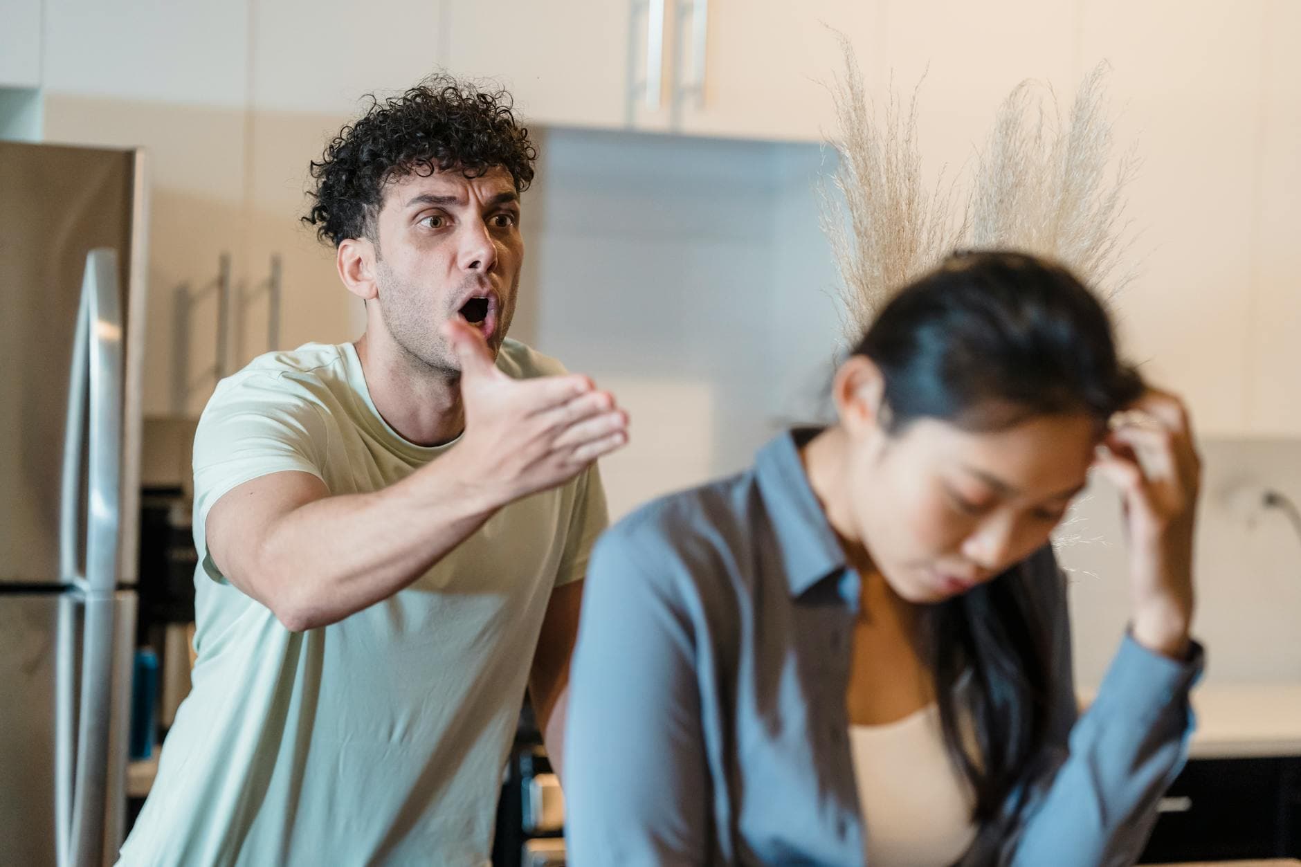 A stressed couple arguing in a modern kitchen, highlighting relationship issues. - managing family conflict spring holidays