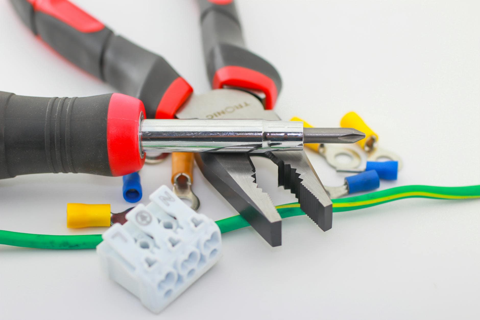 A detailed close-up of hand tools including a screwdriver and pliers with various wiring accessories. - marriage maintenance tips