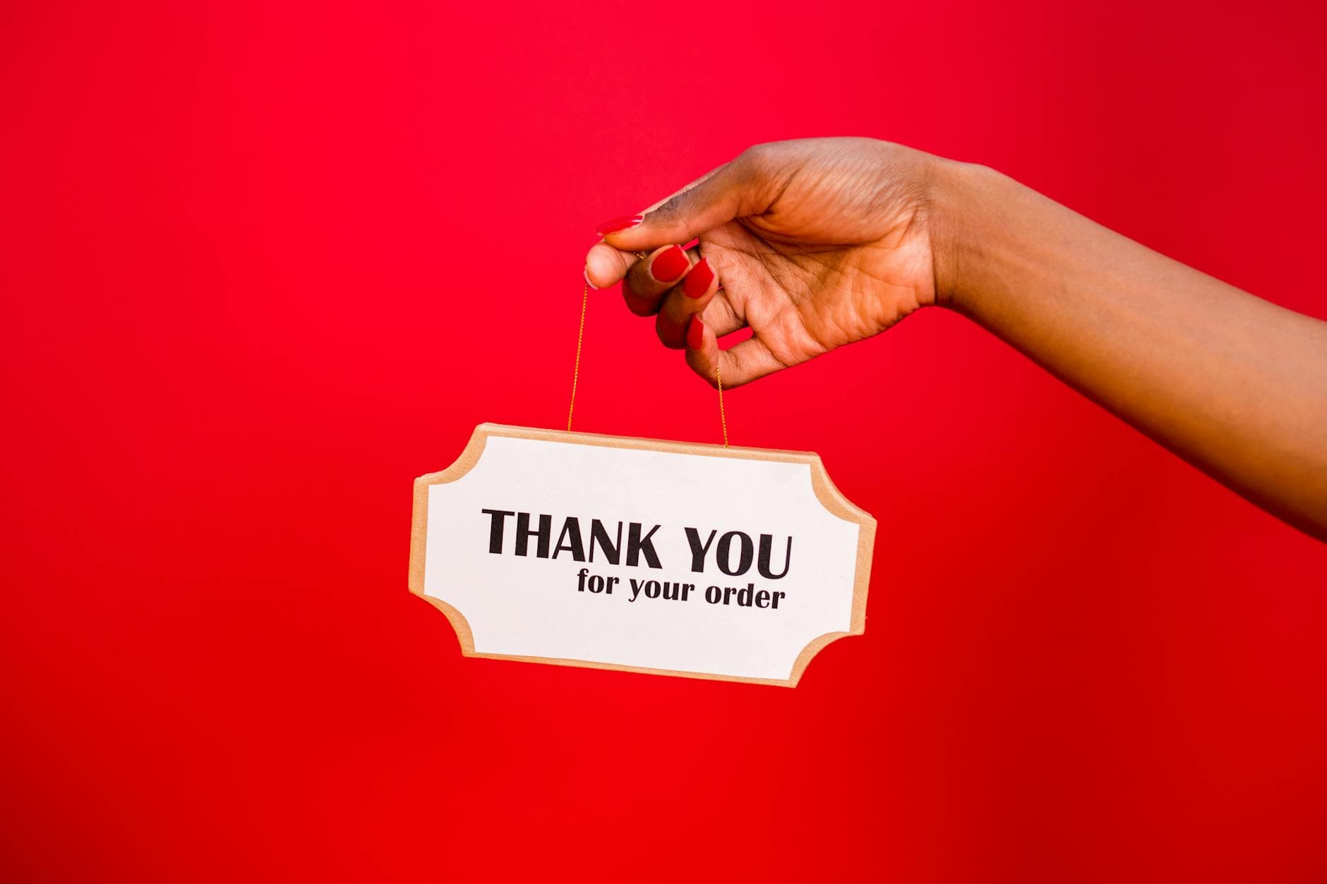 A person holding a thank you sign against a vibrant red background. - refresh your relationship