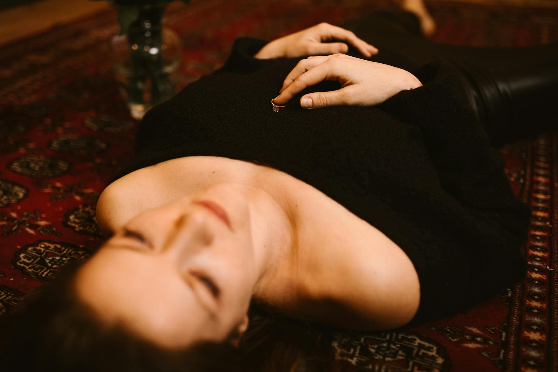 Contemplative woman lying on a patterned rug indoors. Elegant mood. - winter depression mindfulness