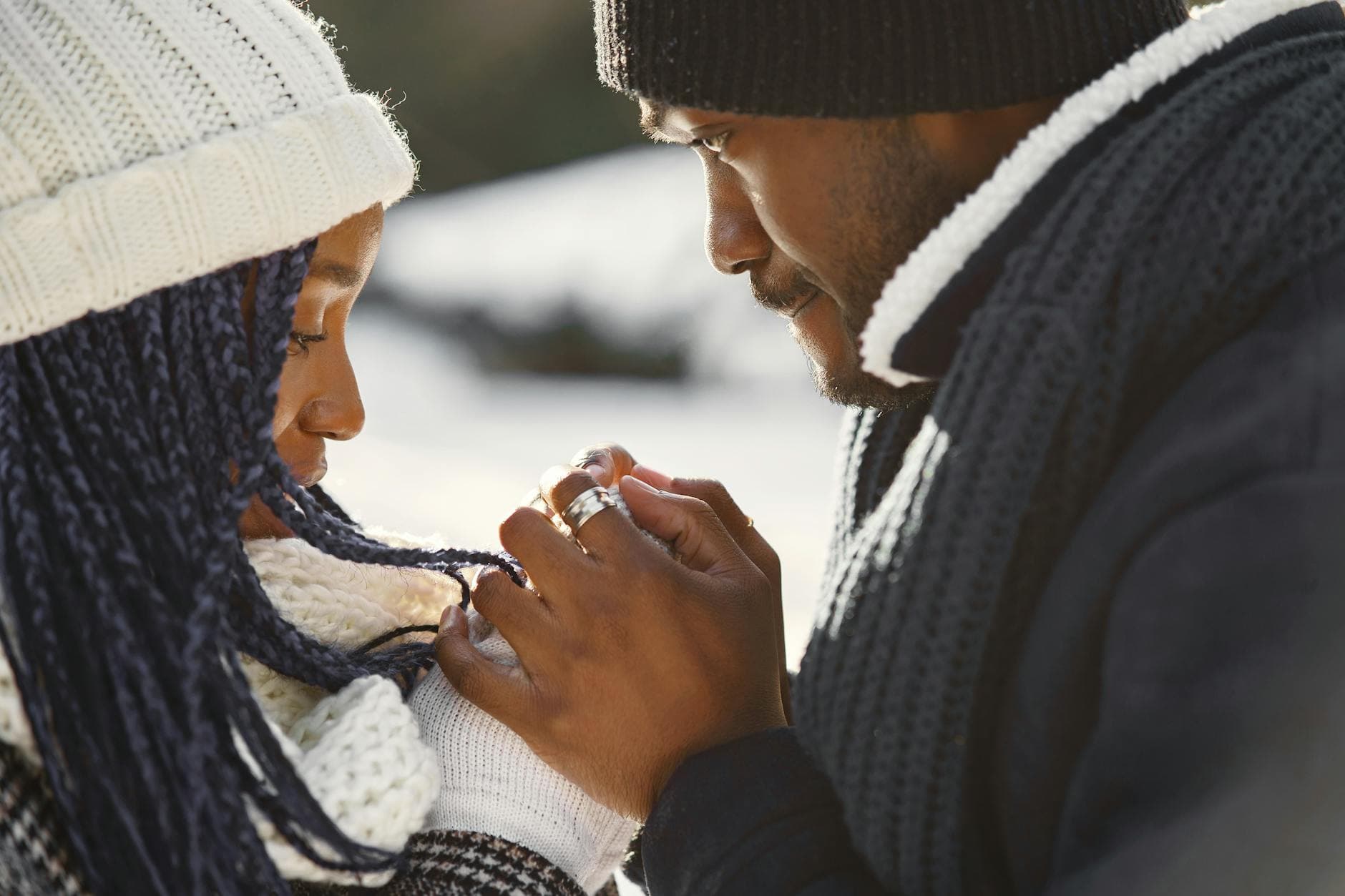 Close-up of a couple holding hands warmly dressed in winter attire outdoors. - winter marriage blues