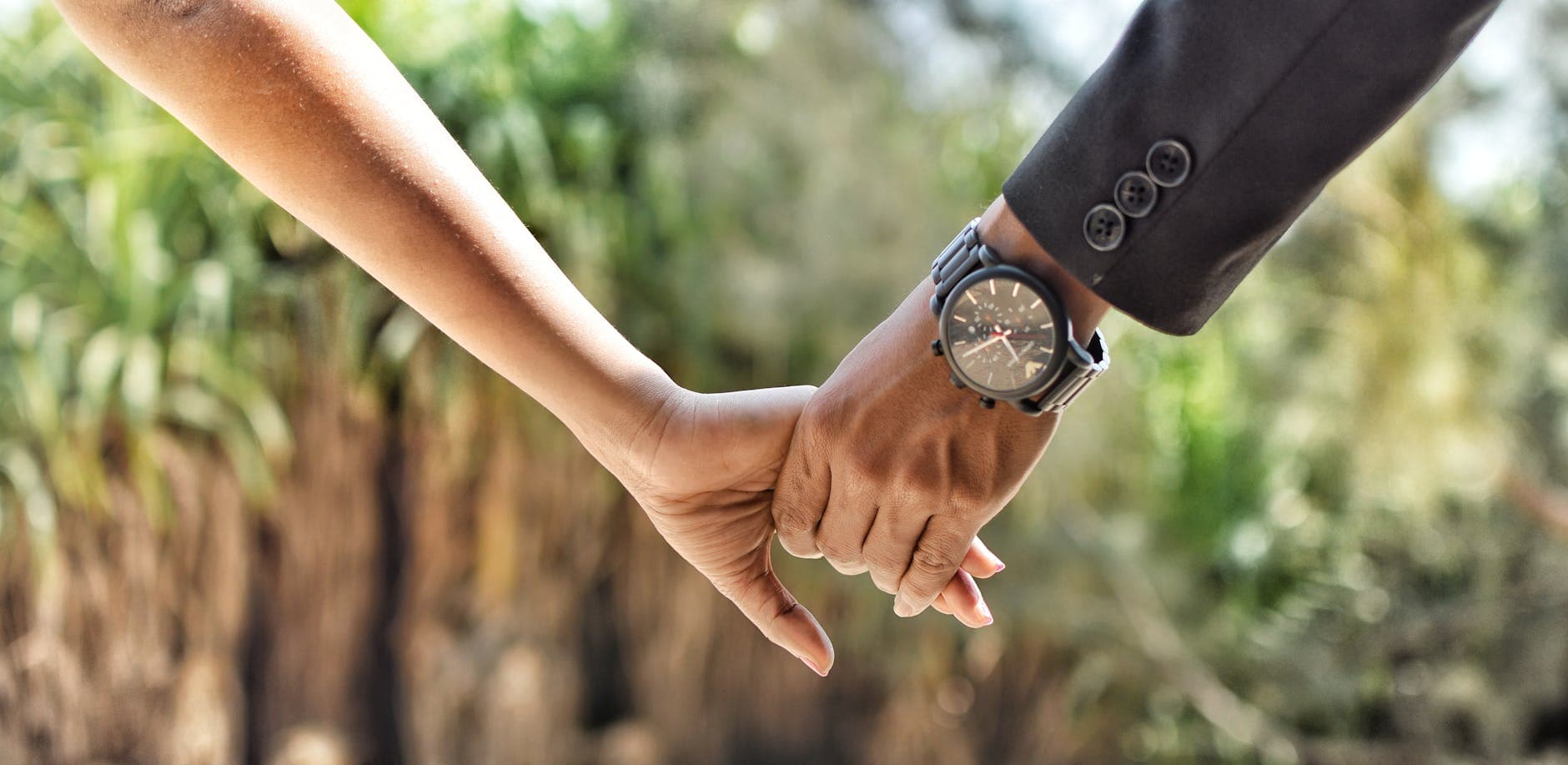 Romantic close-up of a couple holding hands in an outdoor setting, conveying love and connection. - deepen marriage connection