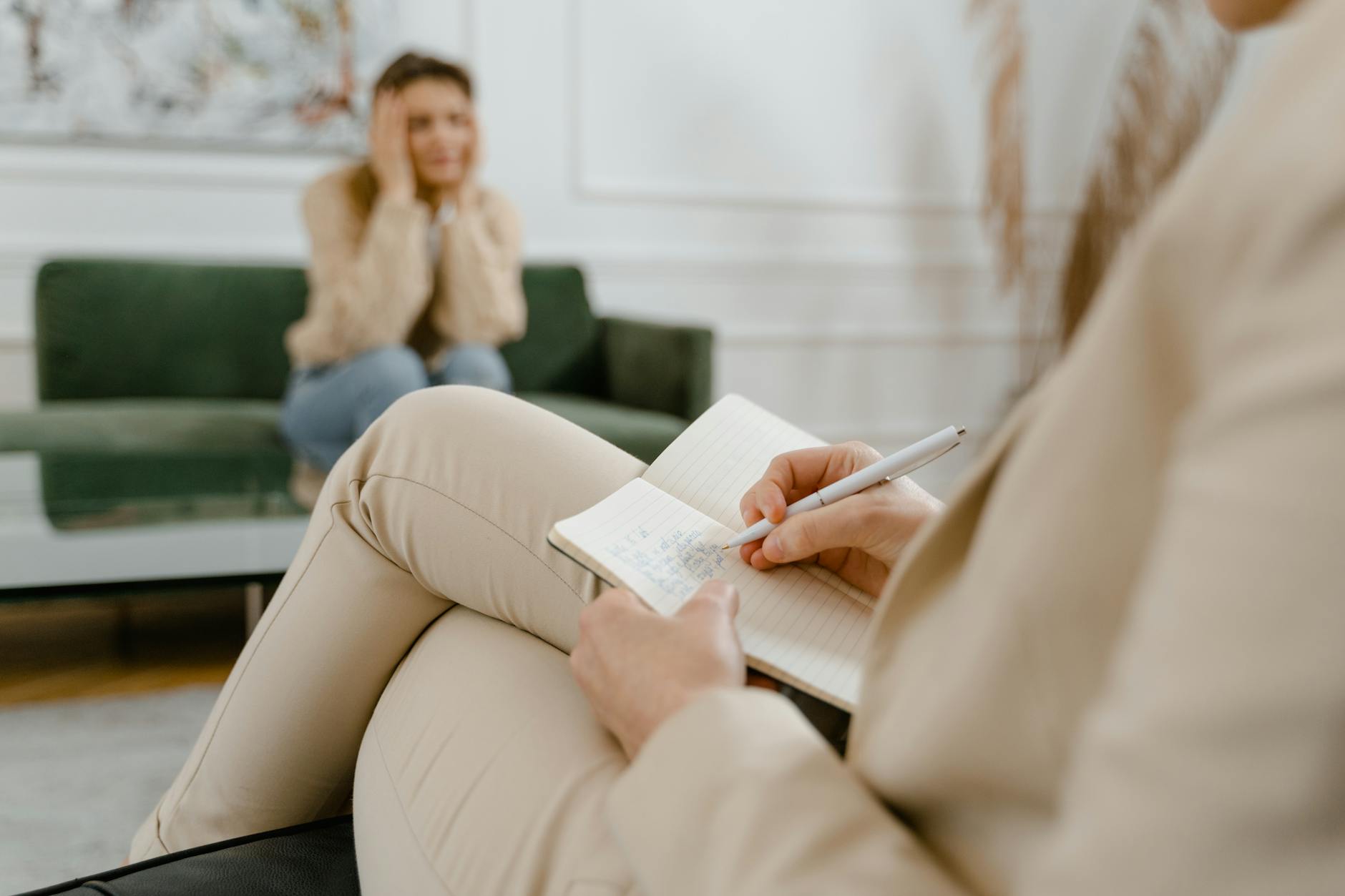 A therapist taking notes during a consultation with a patient, focusing on mental health. - anxiety and depression treatment