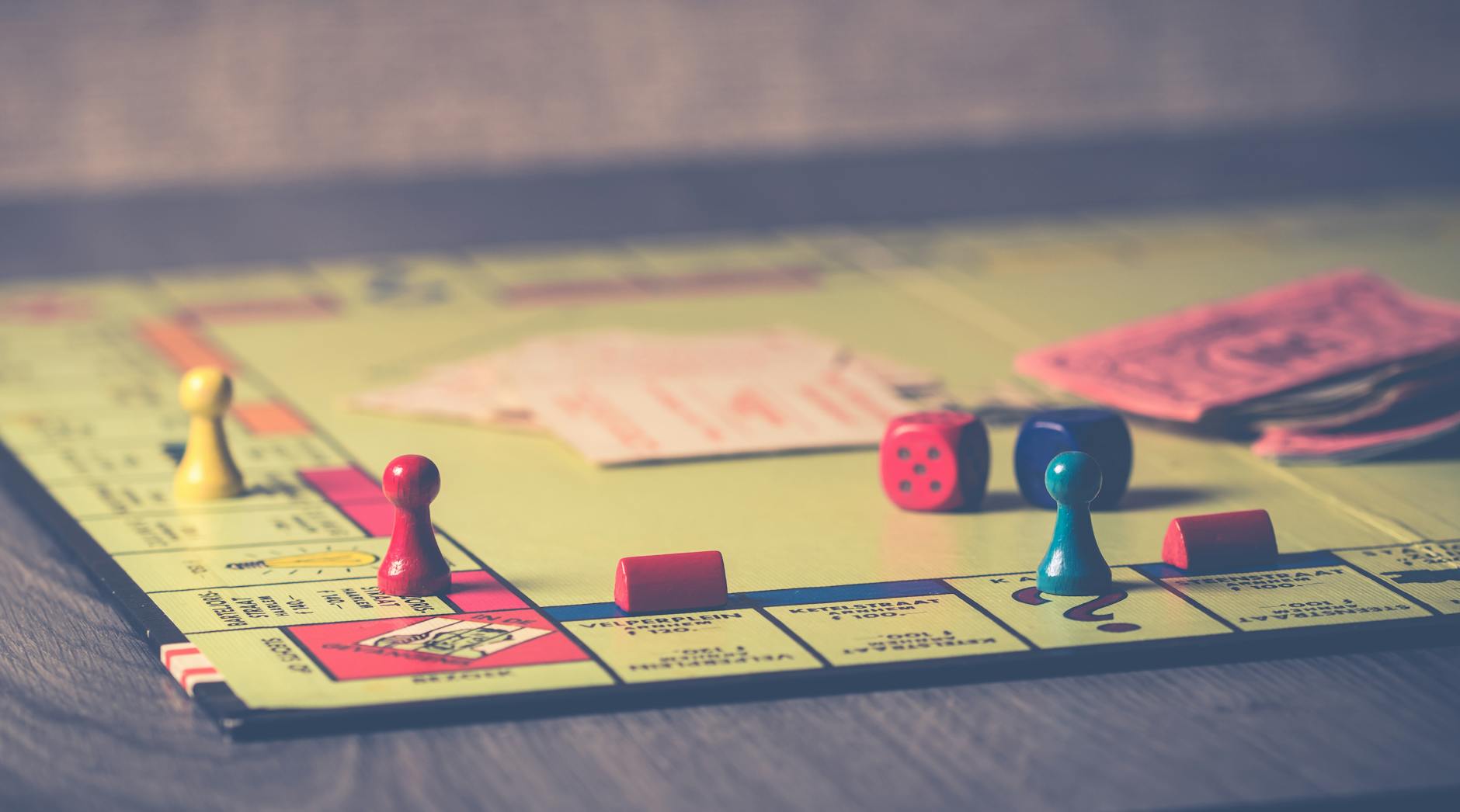 A close-up of a Monopoly board game with pieces and dice scattered around. - blended family communication strategies