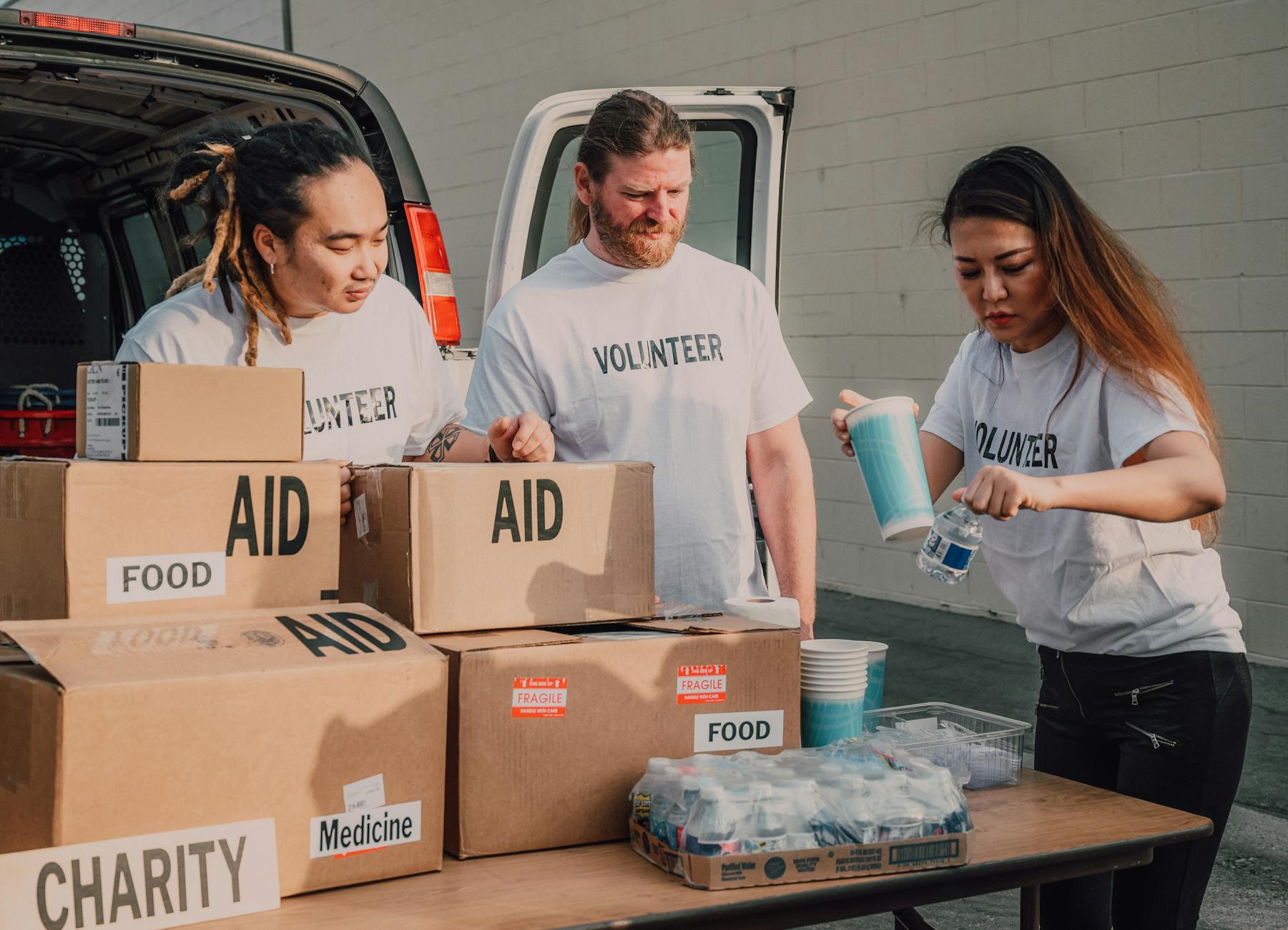 Volunteers sort aid and food boxes for a charity drive, promoting togetherness and social good. - children's empathy winter service