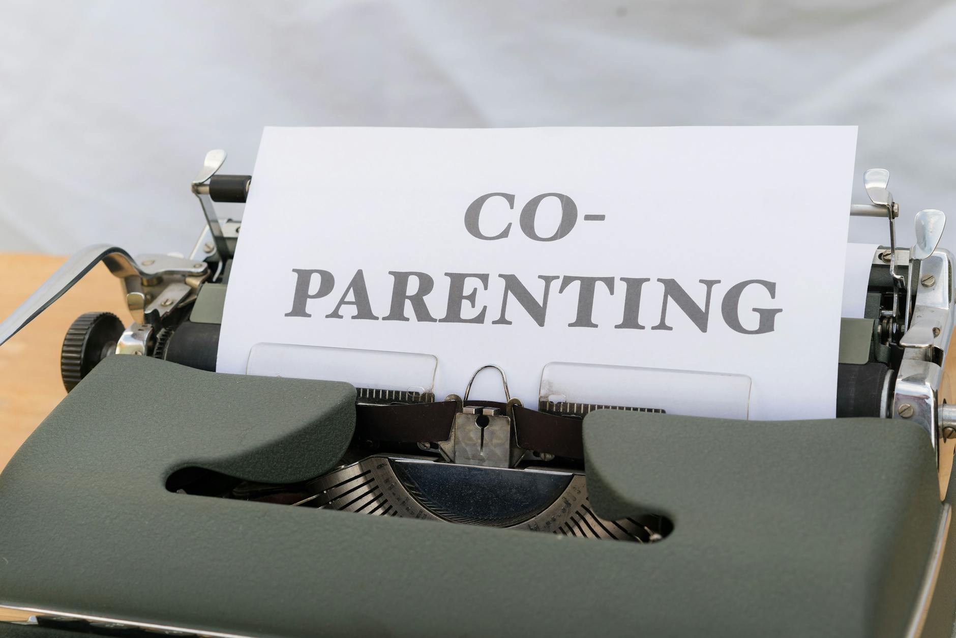 A vintage typewriter displaying a paper with the word 'Co-Parenting', symbolizing shared parenting or custody. - co-parenting communication winter break