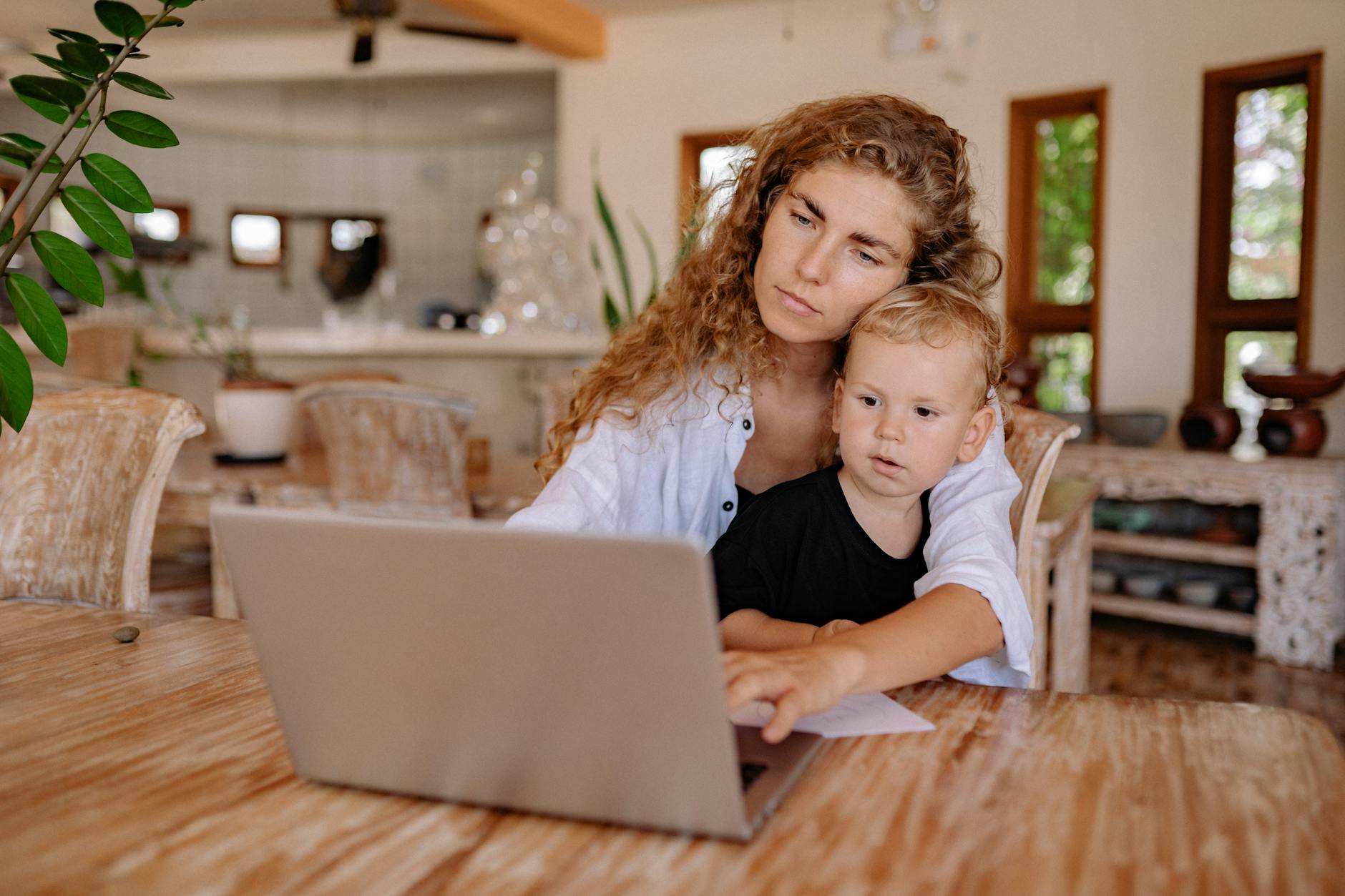Mother and child using a laptop at home, working and bonding in a cozy environment. - co-parenting communication winter break