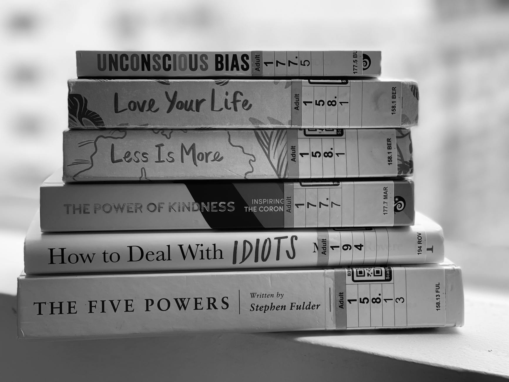 Black and white stack of self-help and inspirational books on a table. - how to deal with a breakup