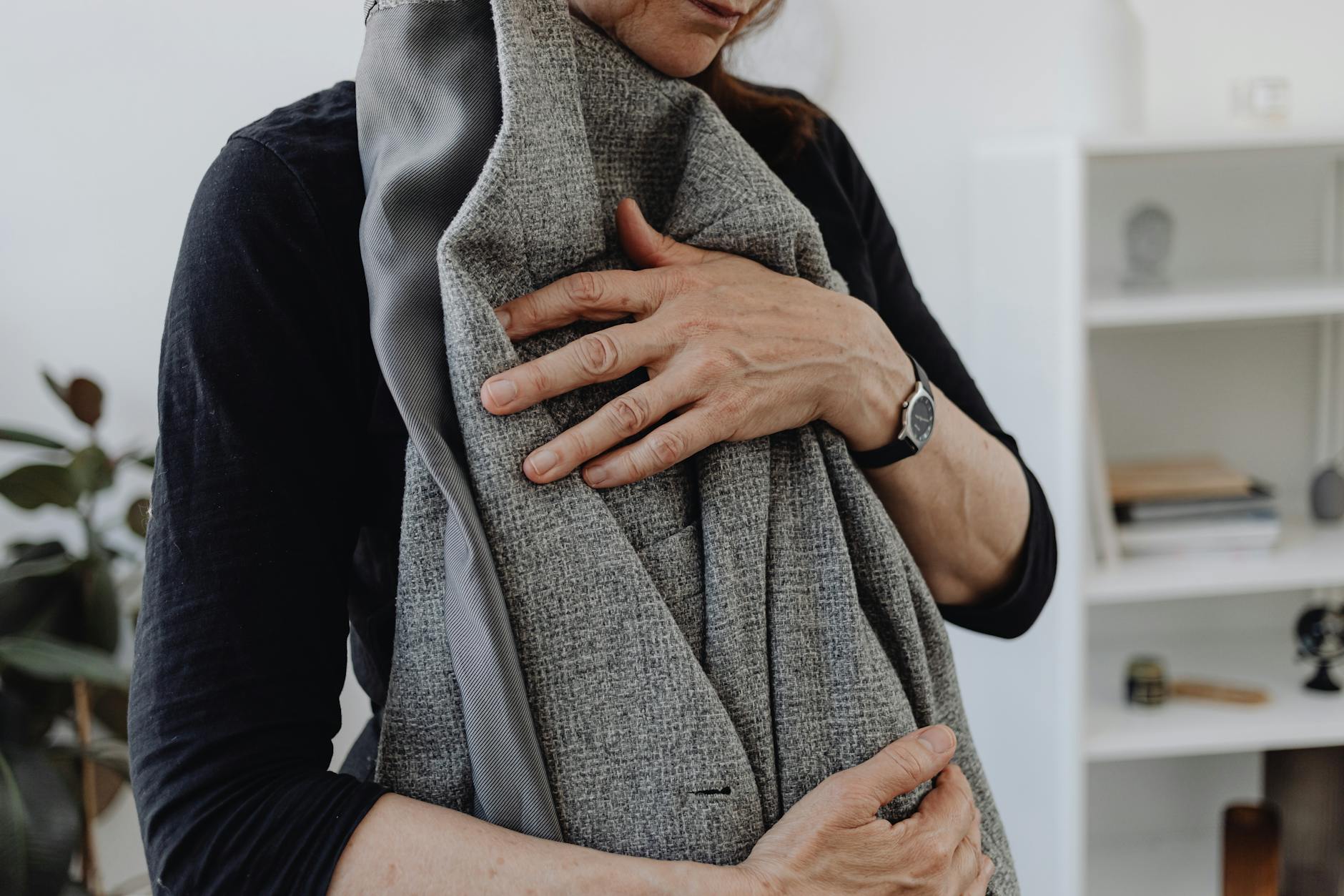 A woman embracing a blazer, symbolizing grief and loss, in a calming home setting. - depression coping mechanisms