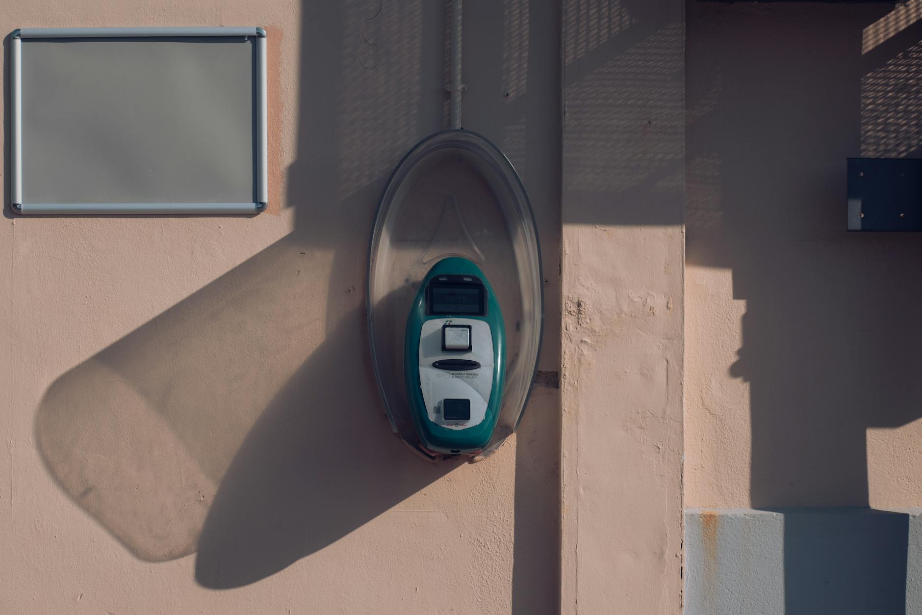 Ticket validator mounted on a wall in Avola, Sicily, casting a shadow in the afternoon light. - emotional validation definition