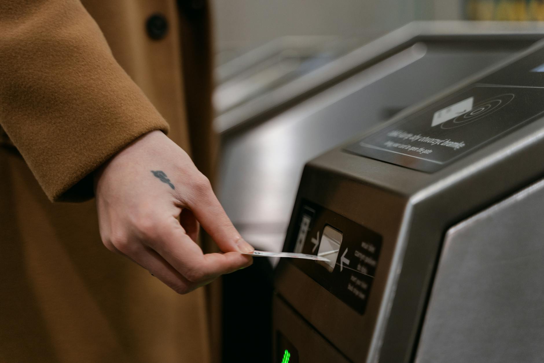 A person inserting a ticket into a turnstile at a train station, showcasing public transportation usage. - emotional validation definition