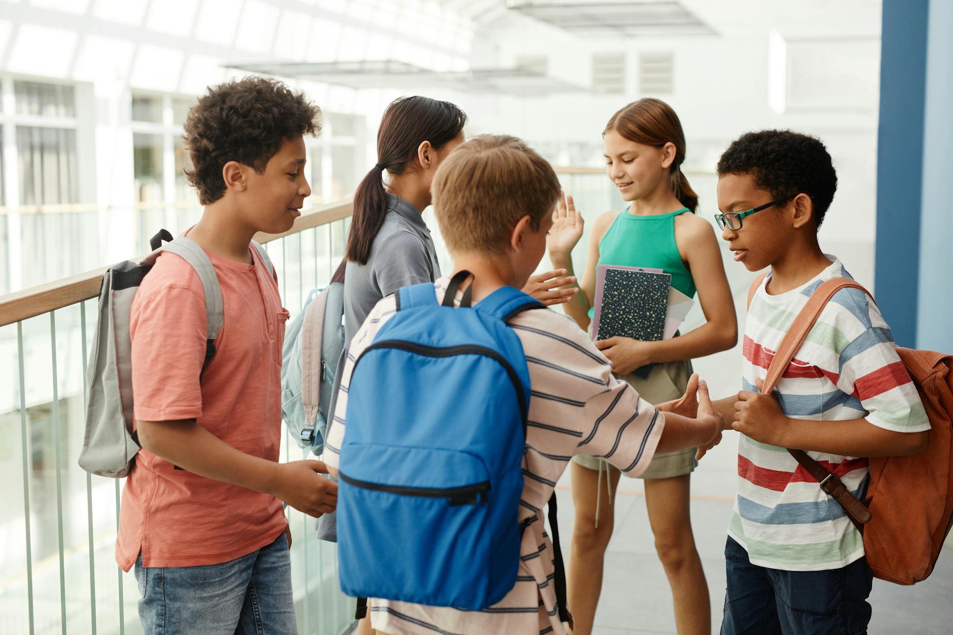 A diverse group of students interacting in a school hallway, fostering social connections. - february school break parenting