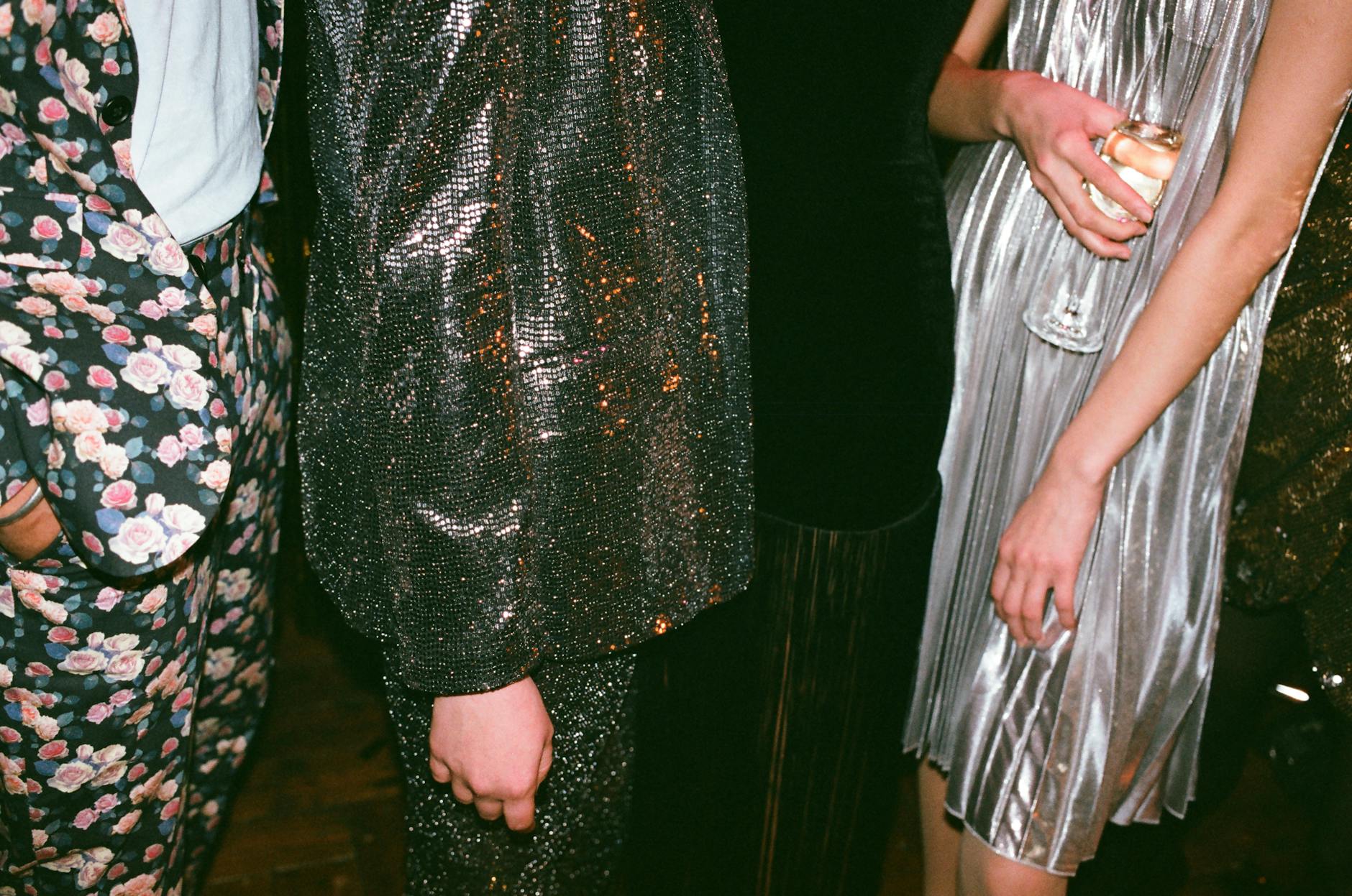 Group of adults in stylish glitter outfits and dresses at a glamorous evening event. - introvert dating advice