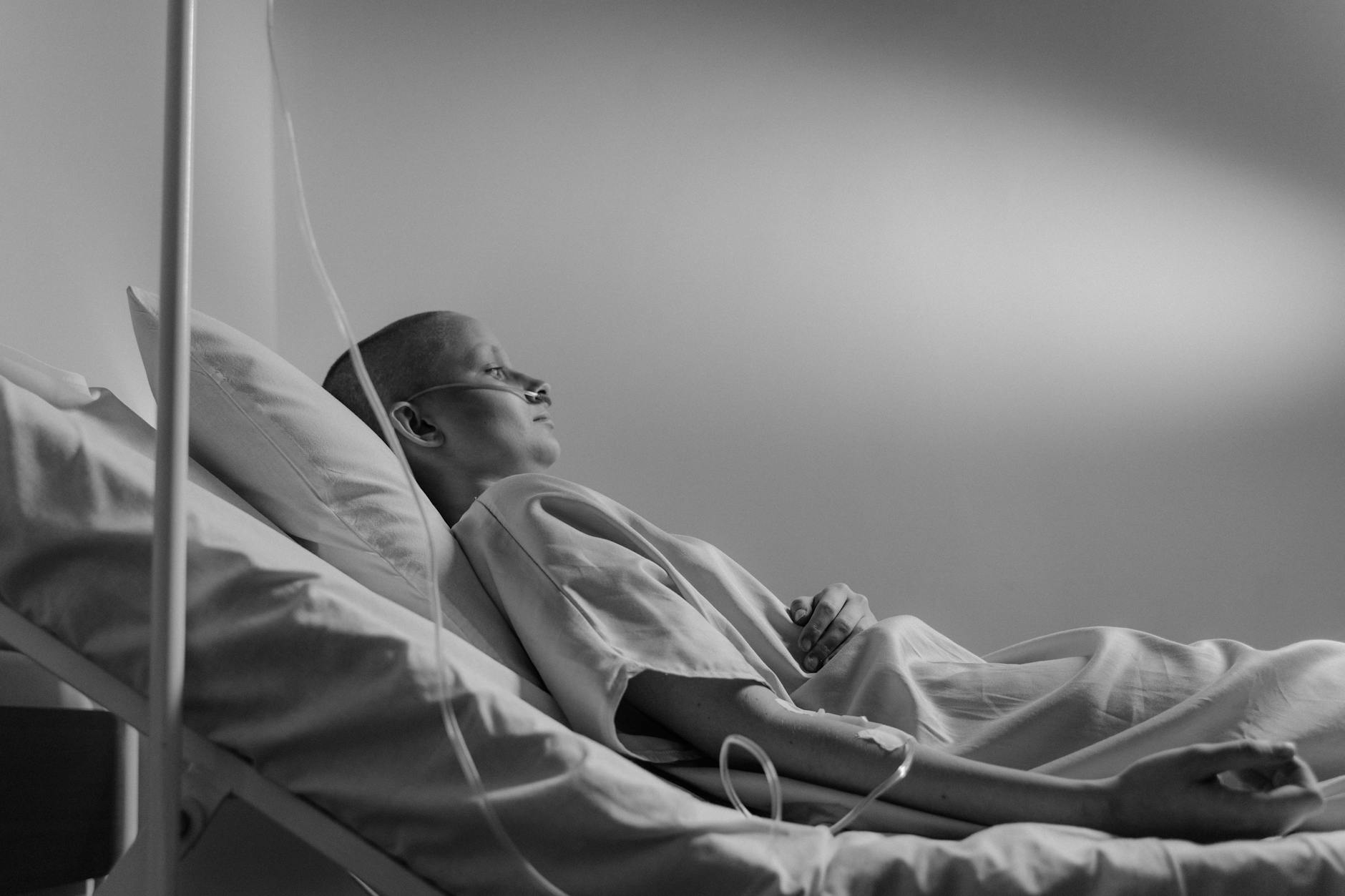 Black and white image of a patient in a hospital bed wearing a gown with a nasal cannula. - latest postpartum depression treatments