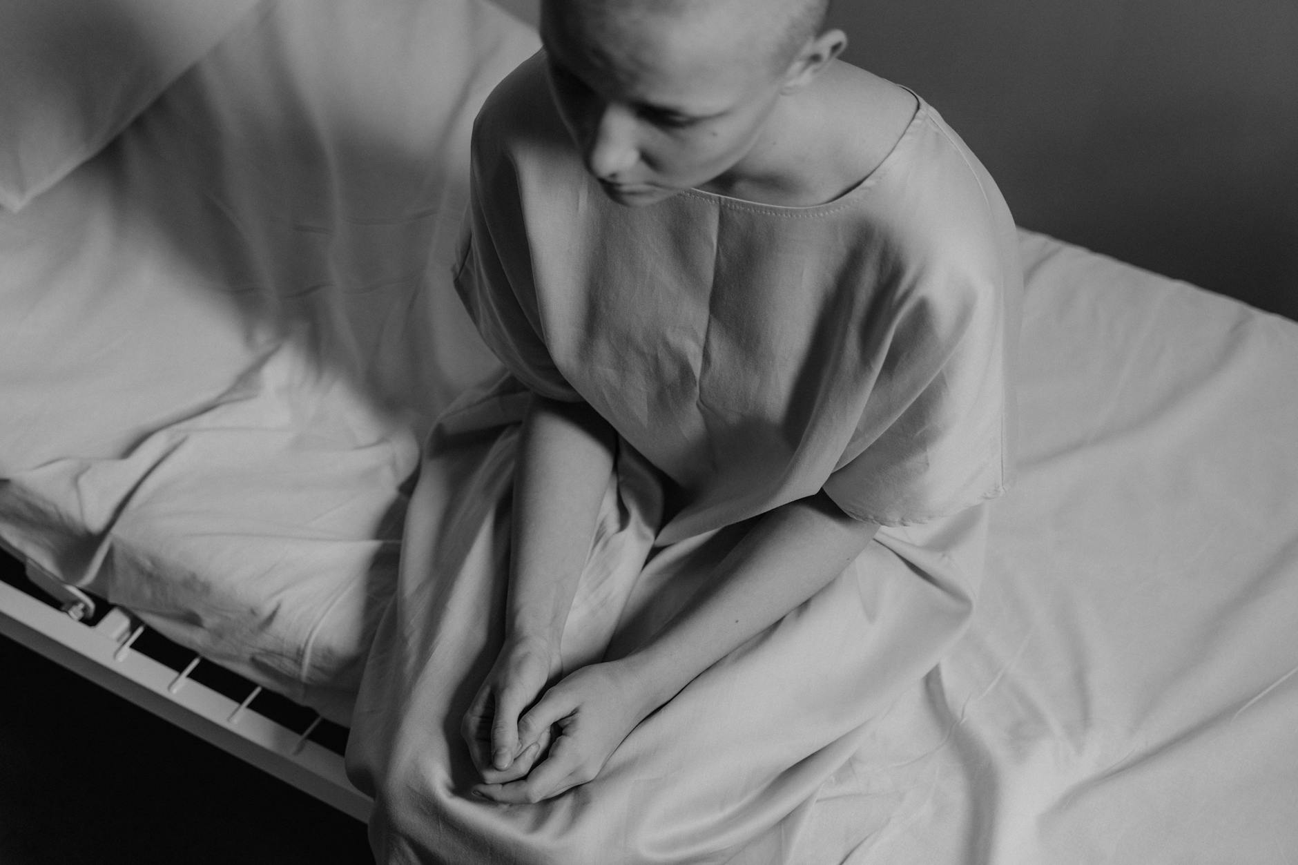 A poignant black and white photograph of a woman in a hospital setting, expressing vulnerability. - light therapy for sad