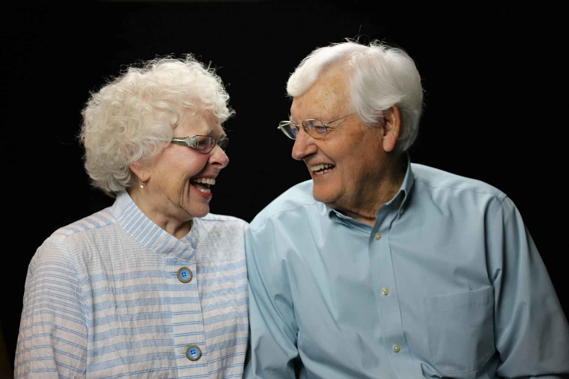 Elderly couple sharing a joyful moment with a loving laugh. - maintain romance long term