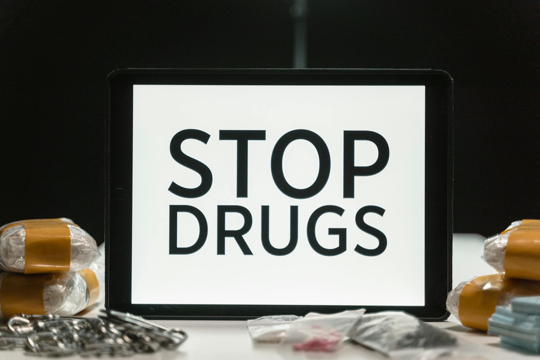 Tablet screen displaying anti-drug message surrounded by packaged substances, promoting awareness. - narcissistic abuse recovery