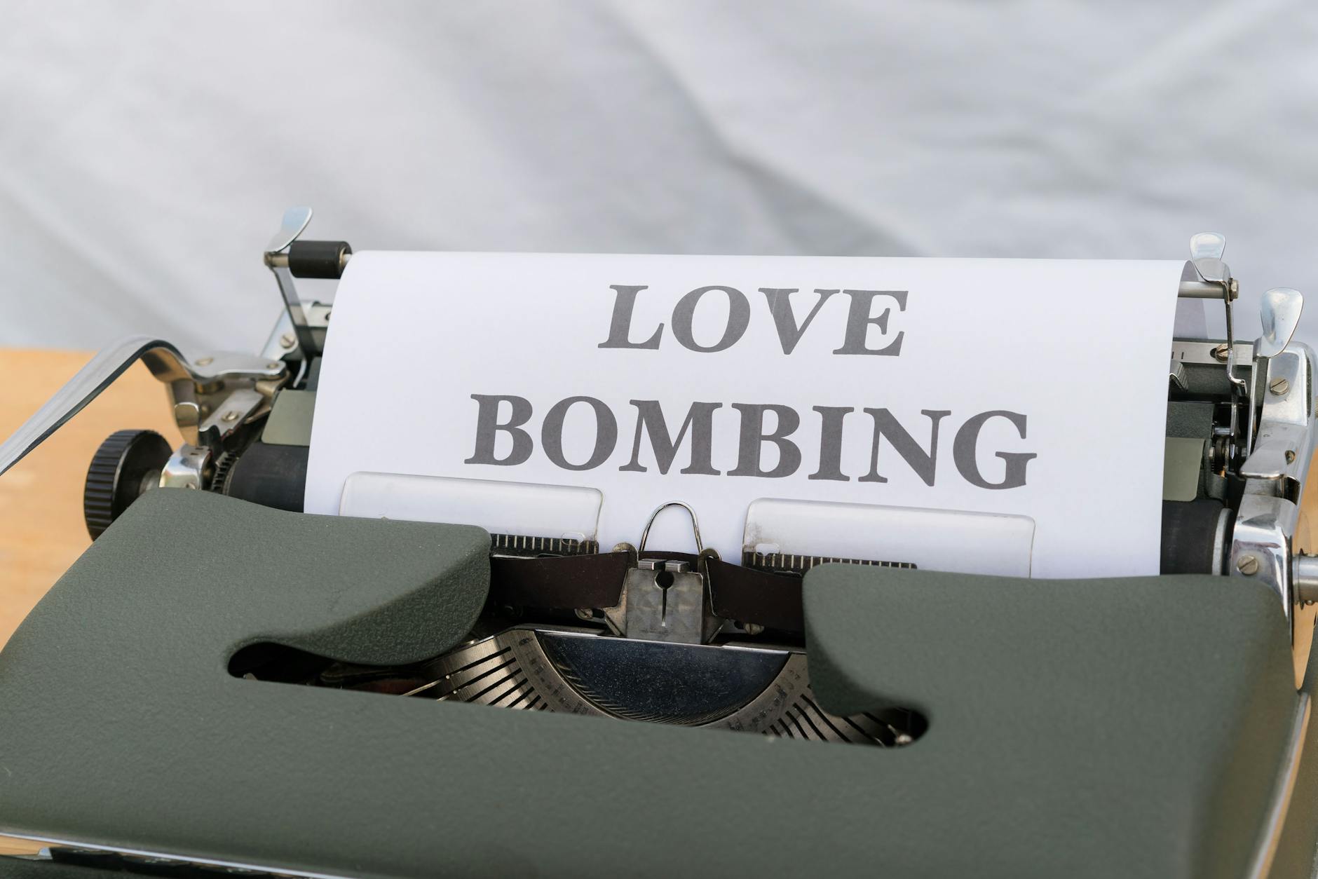 Close-up of a typewriter displaying the phrase 'Love Bombing' on paper. - narcissistic relationship signs