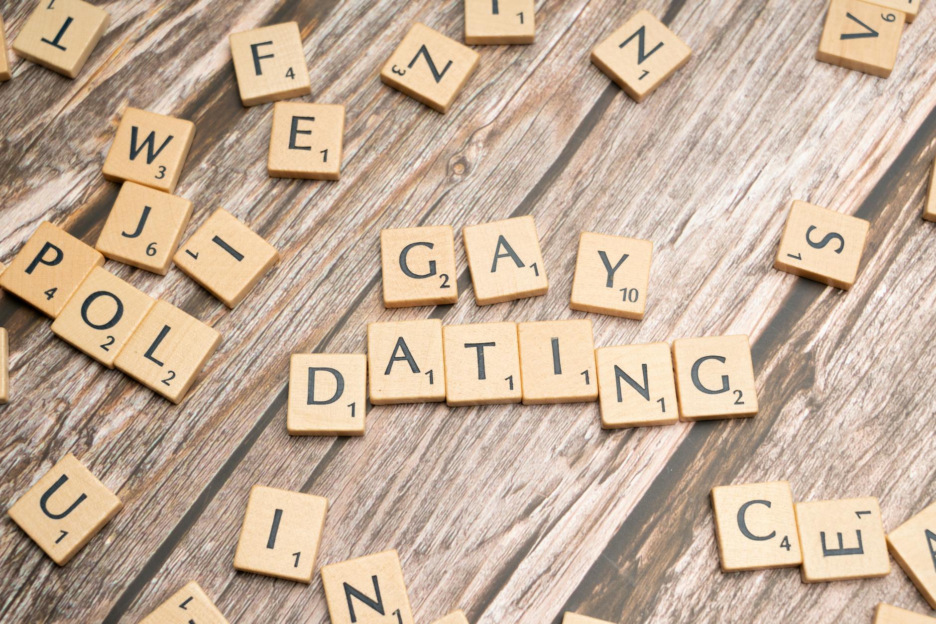Scrabble tiles spelling 'Gay Dating' on a rustic wooden background, representing LGBTQ themes. - online dating tips men