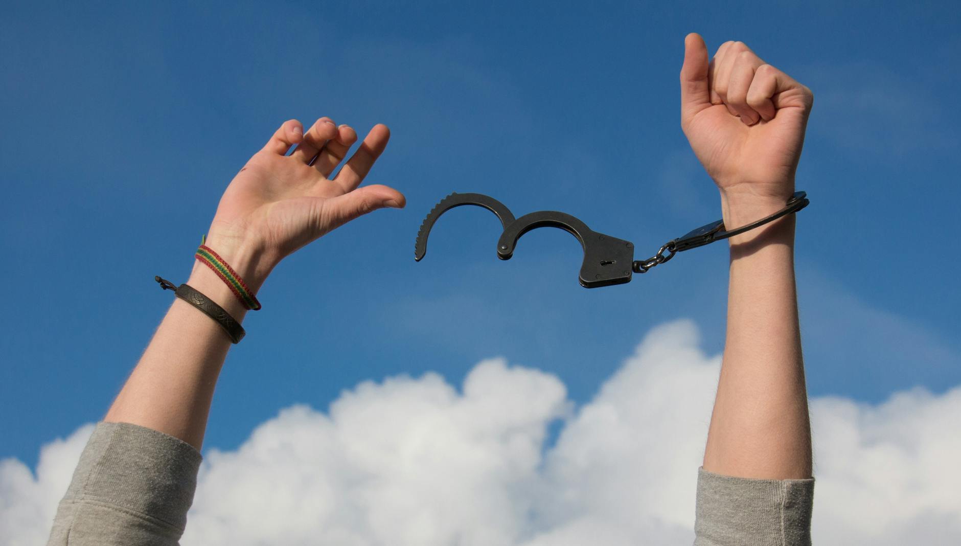 Symbolic image of freedom with open handcuffs against a bright blue sky. - overcoming winter blues
