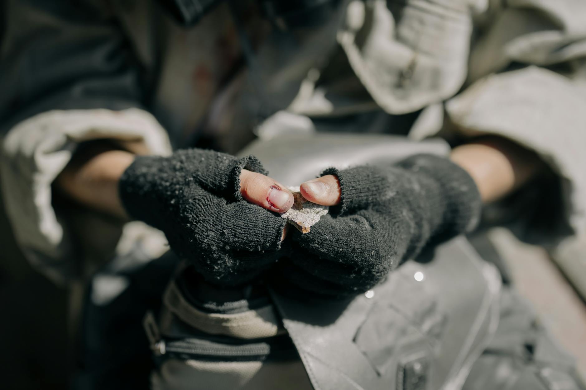 Rugged hands with fingerless gloves holding a fragment, depicting survival and resilience. - post-holiday relationship struggles