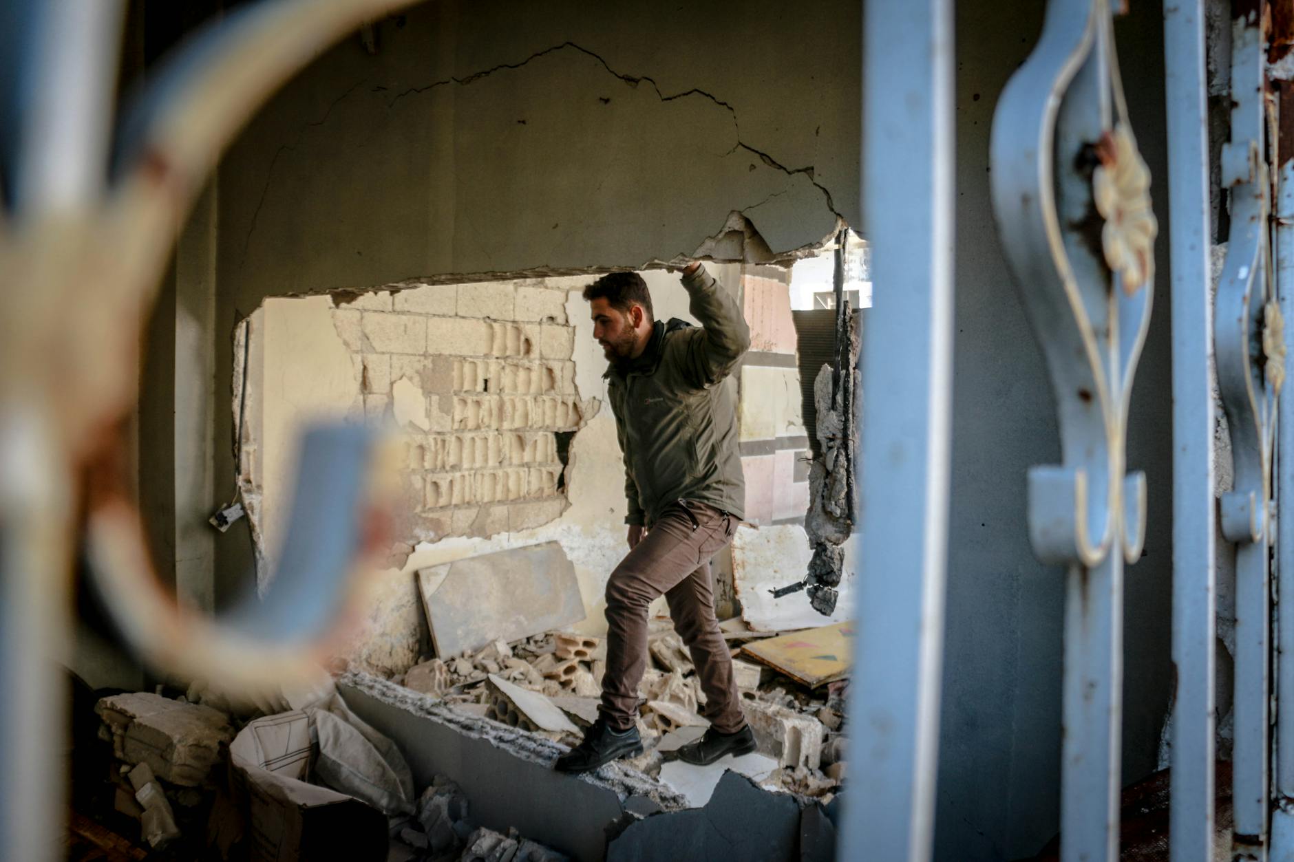 A man navigates through a damaged building in Idlib, Syria, symbolizing resilience amidst destruction. - rebuilding trust after affair