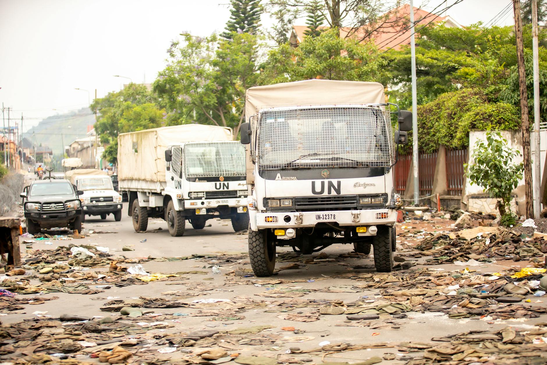 UN trucks travel through a debris-filled street, highlighting urban challenges. - rebuilding trust after affair