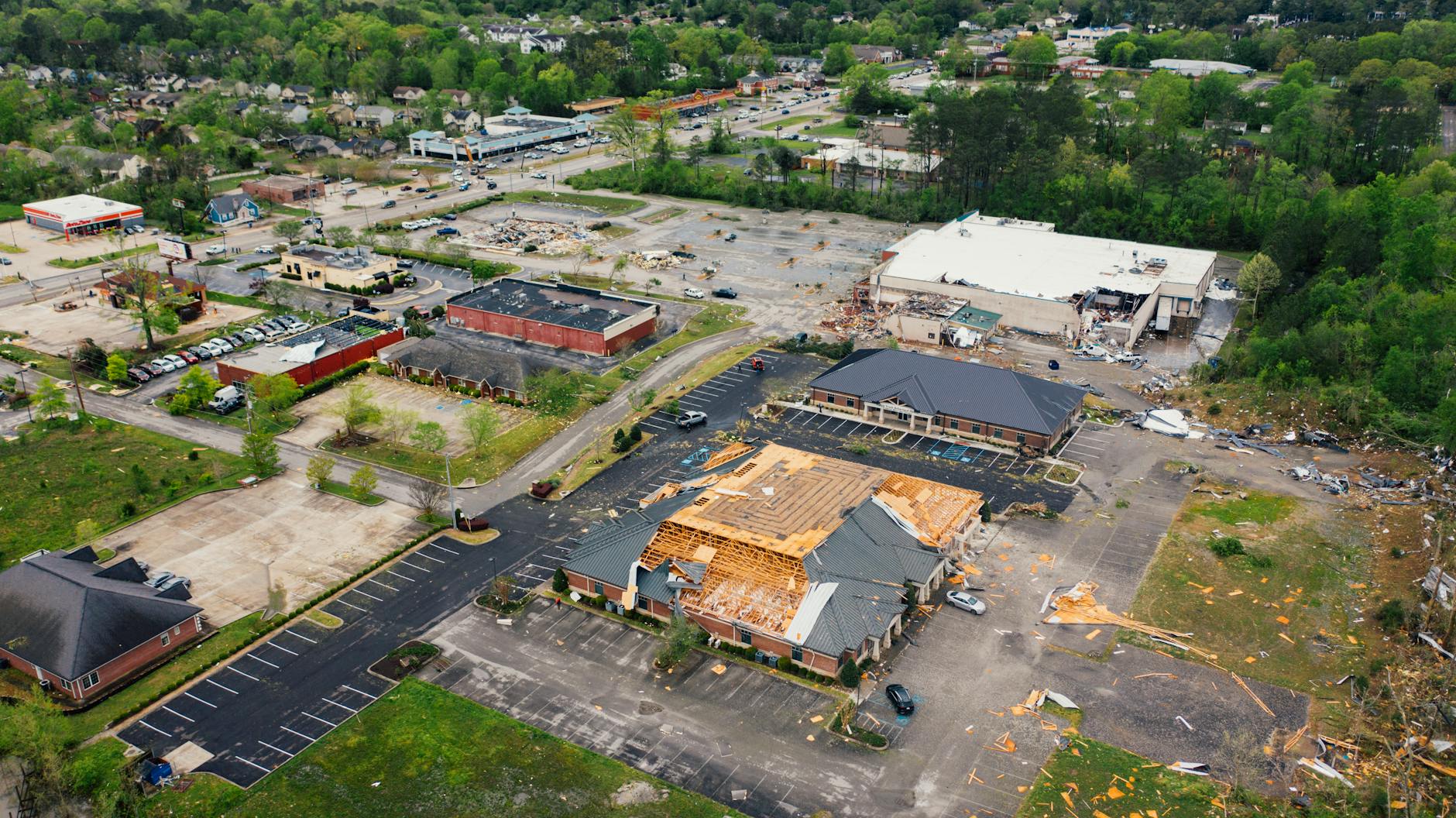 Aerial view of terrible consequences of thunderstorm on small town buildings with ruined roof and uprooted trees - rebuilding trust in marriage