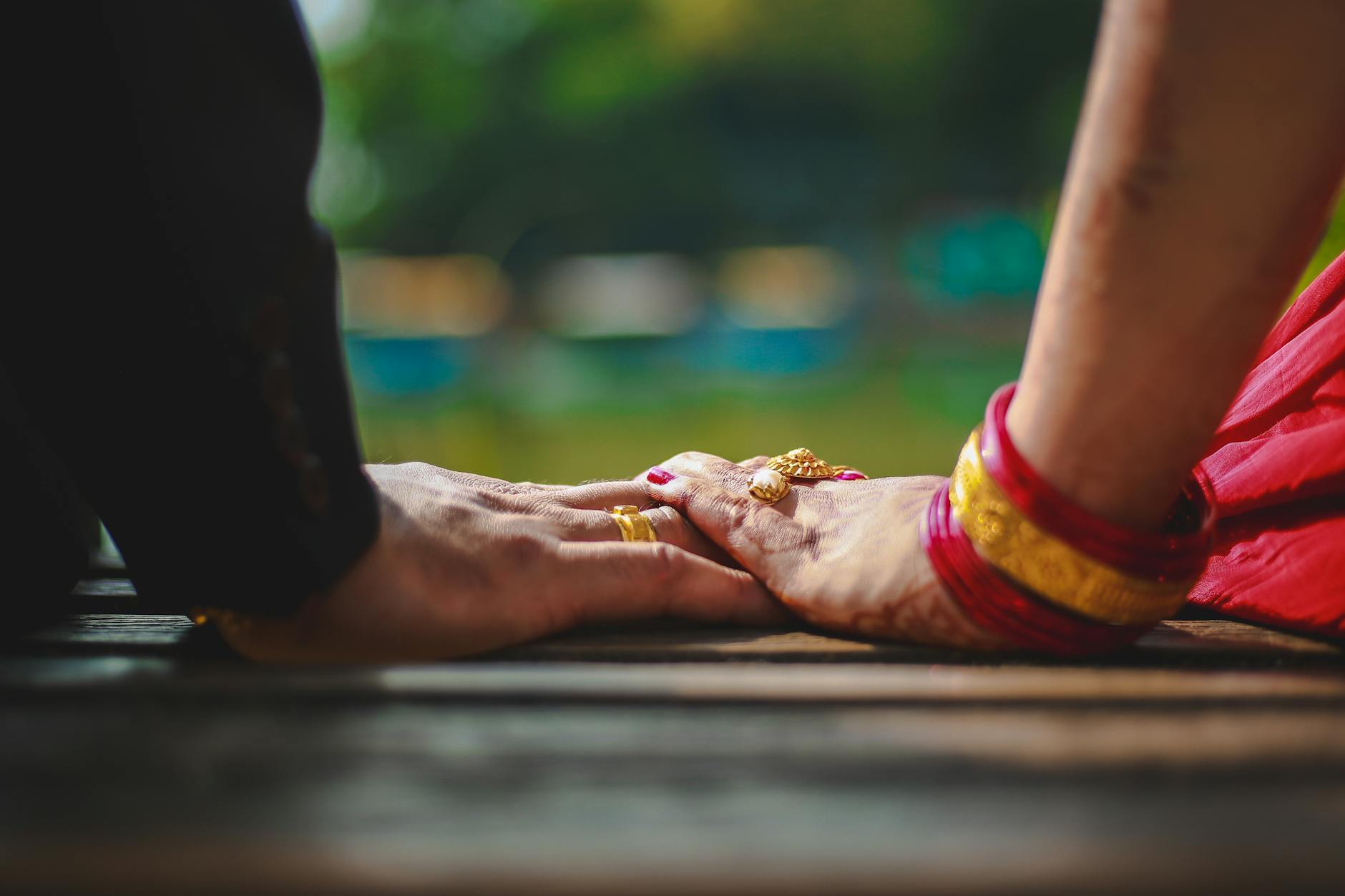 Close-up of a couple's hands touching, showcasing gold rings and traditional attire in Pokhara, Nepal. - rebuilding trust in marriage