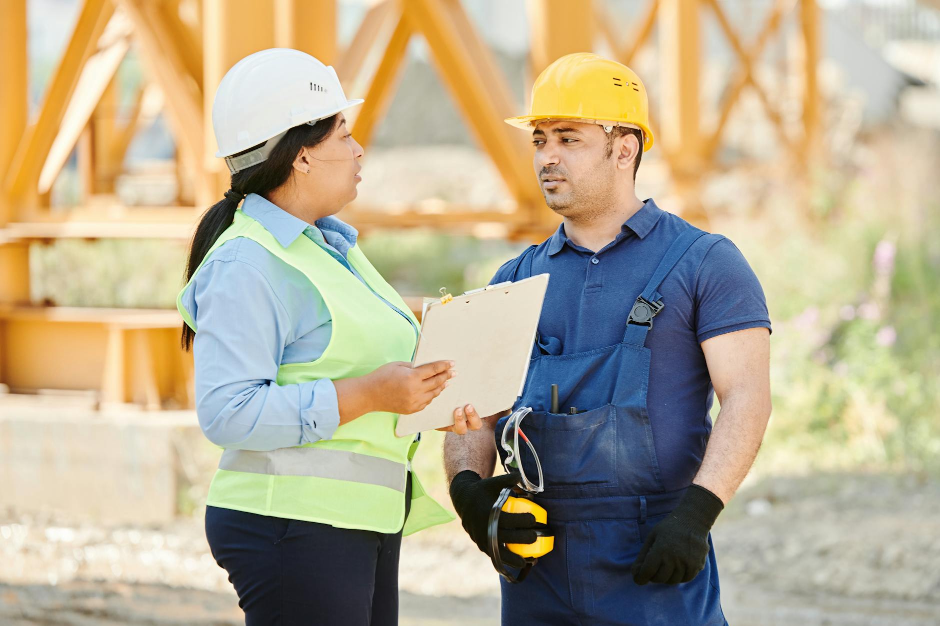 Male and female construction workers talking with safety gear at an outdoor site. - rebuilding trust quotes