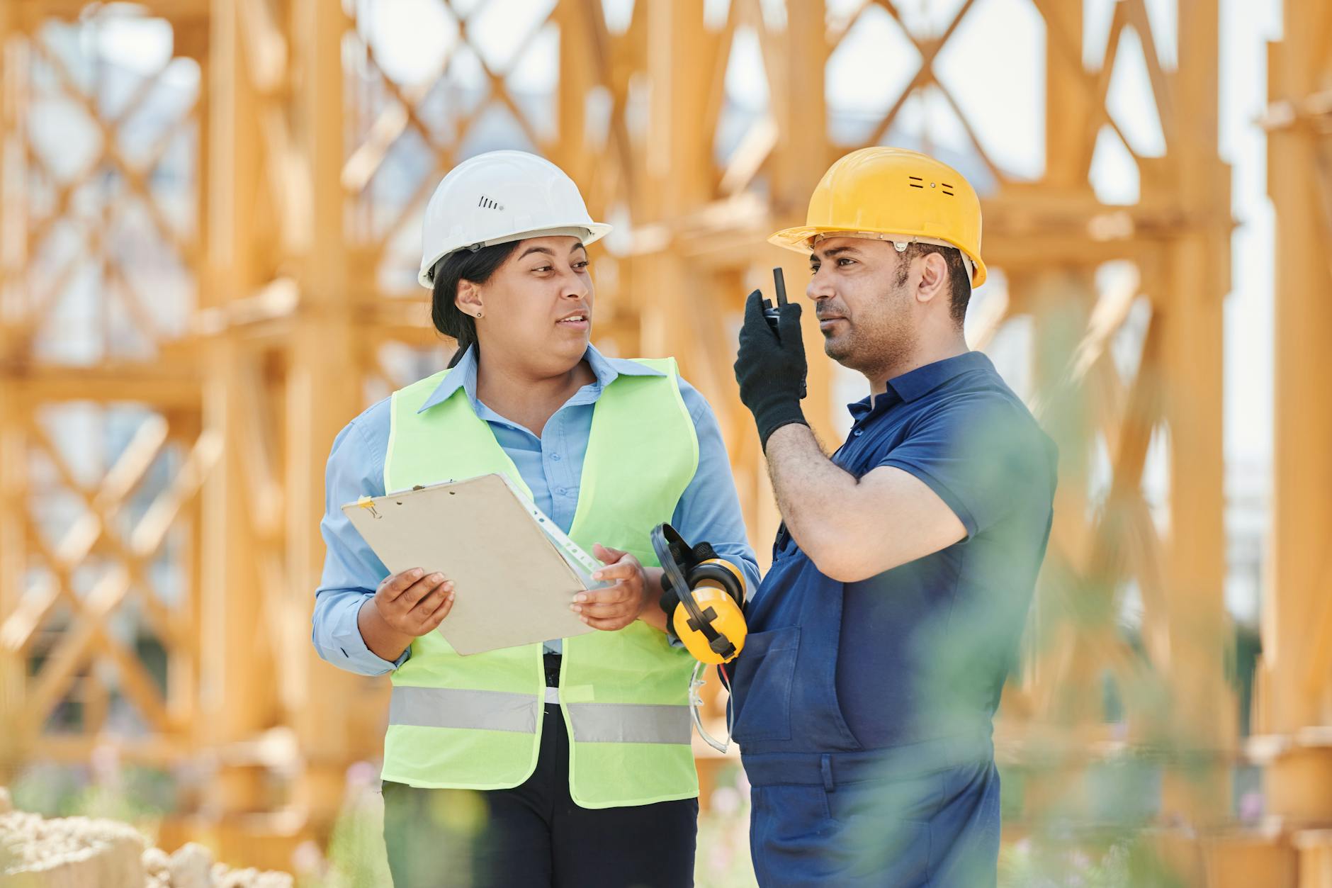 Engineers in safety gear discussing a construction project outdoors with visible scaffolding. - rebuilding trust quotes
