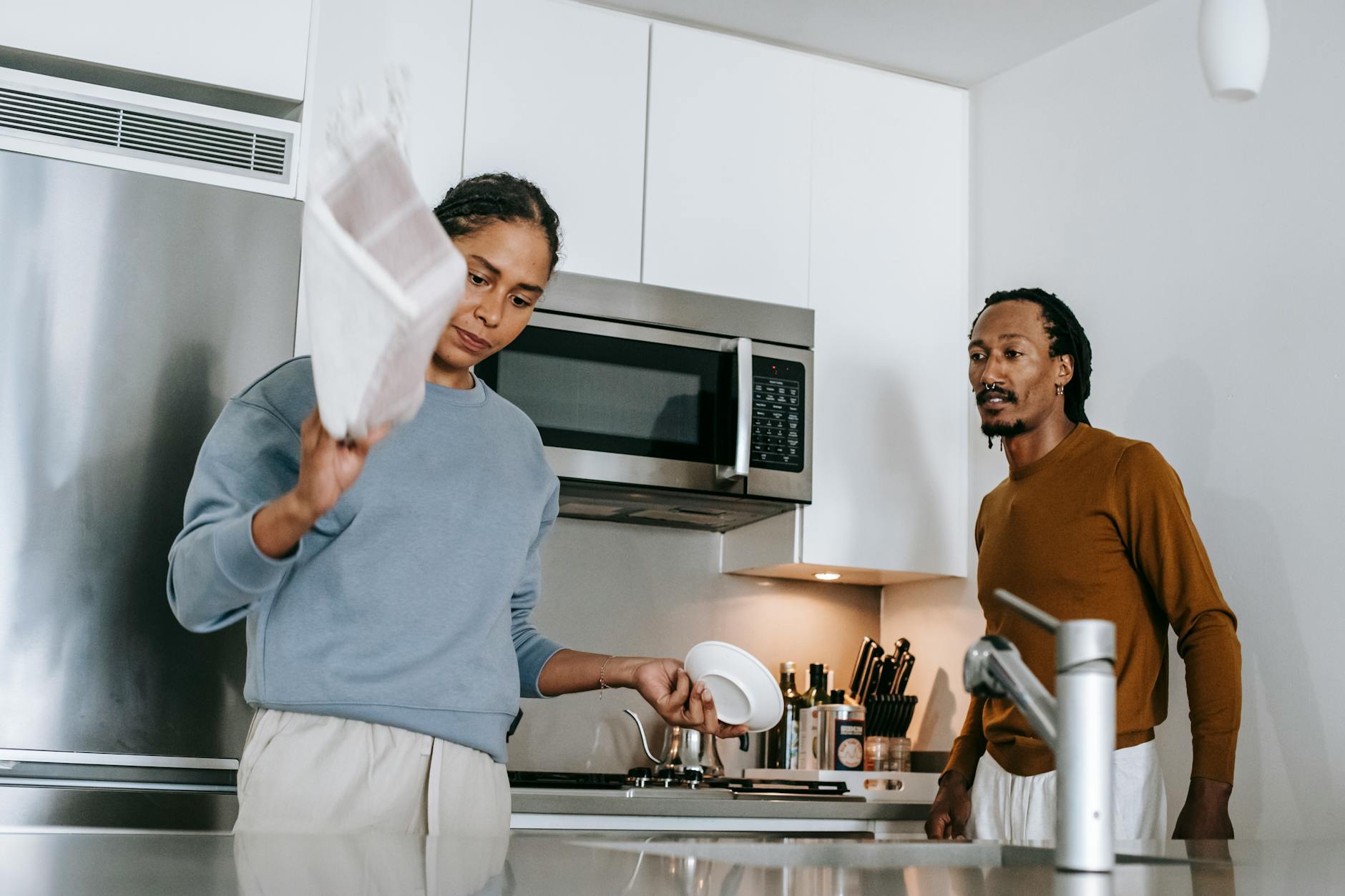 African American couple having a serious discussion in the kitchen, expressing emotions and opinions. - resolve vacation disagreements