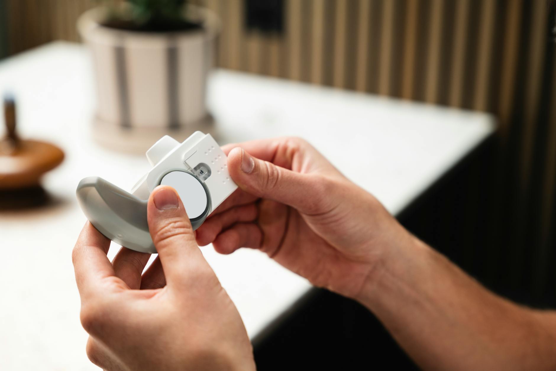 Close-up of hands holding an asthma inhaler, indoors in a modern setting. - seasonal affective disorder symptoms