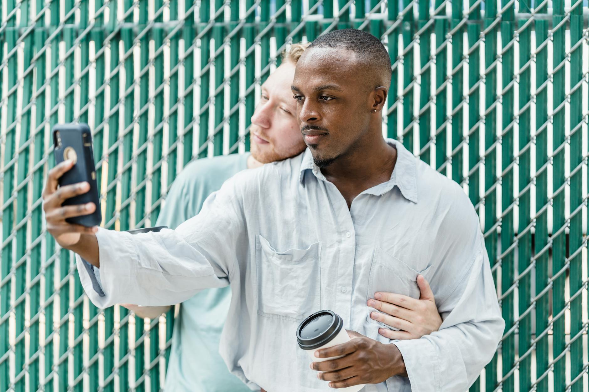 Interracial couple taking a selfie with a smartphone, expressing joy and togetherness. - shared relationship goals
