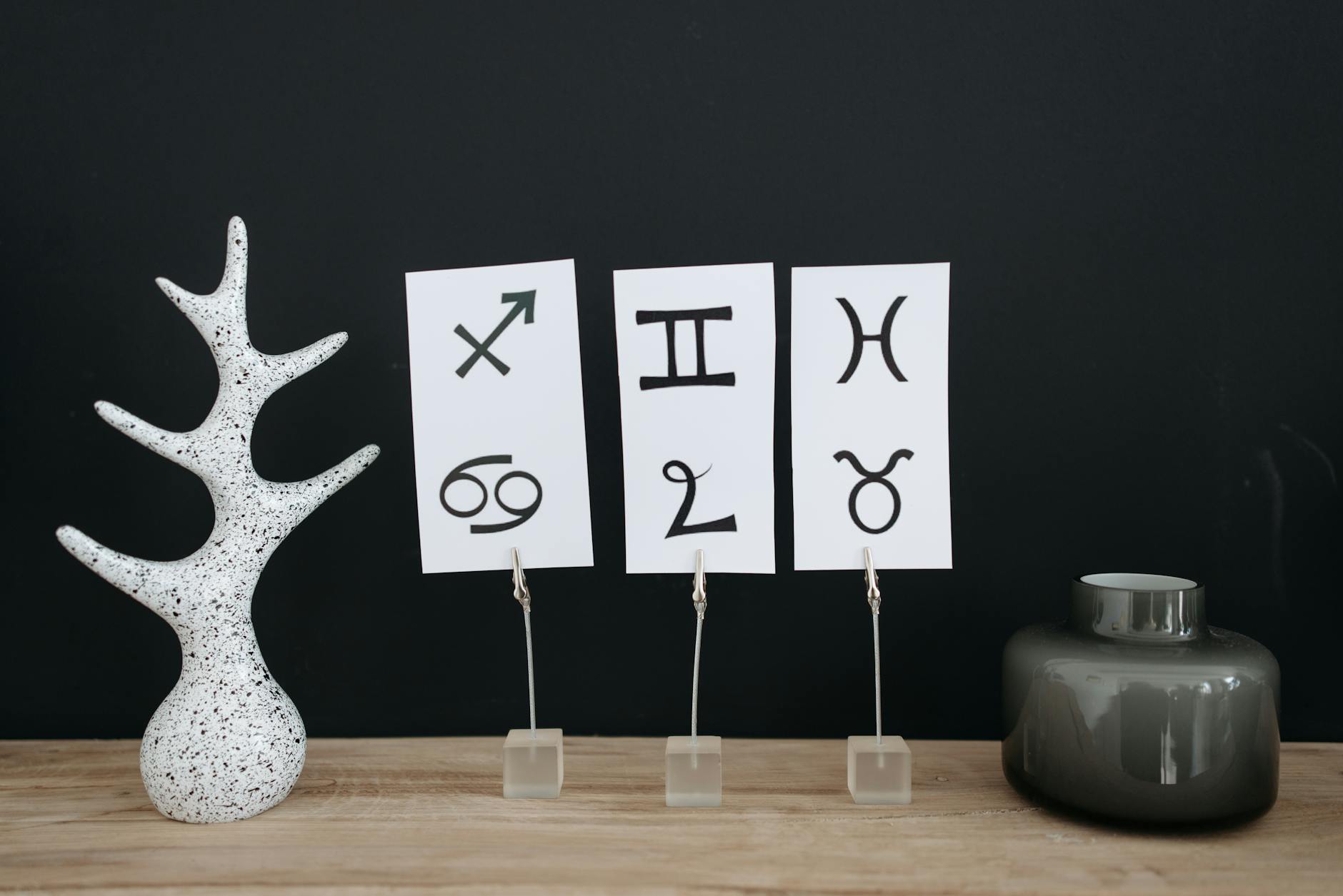 Minimalist decor showcasing zodiac signs with modern elements on a wooden table. - toxic relationship zodiac signs
