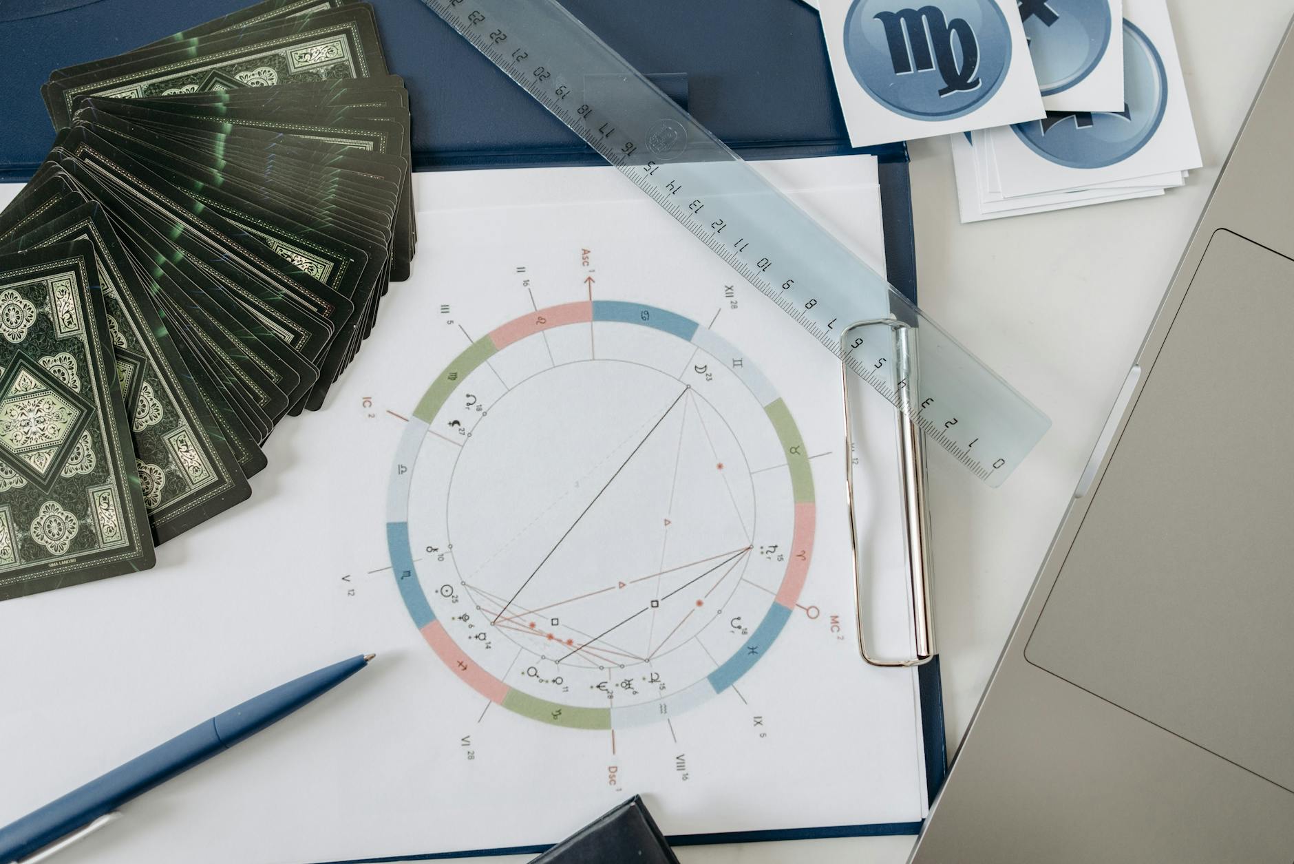 Flat lay of astrology tools, including tarot cards and a natal chart, on a desk. - toxic relationship zodiac signs