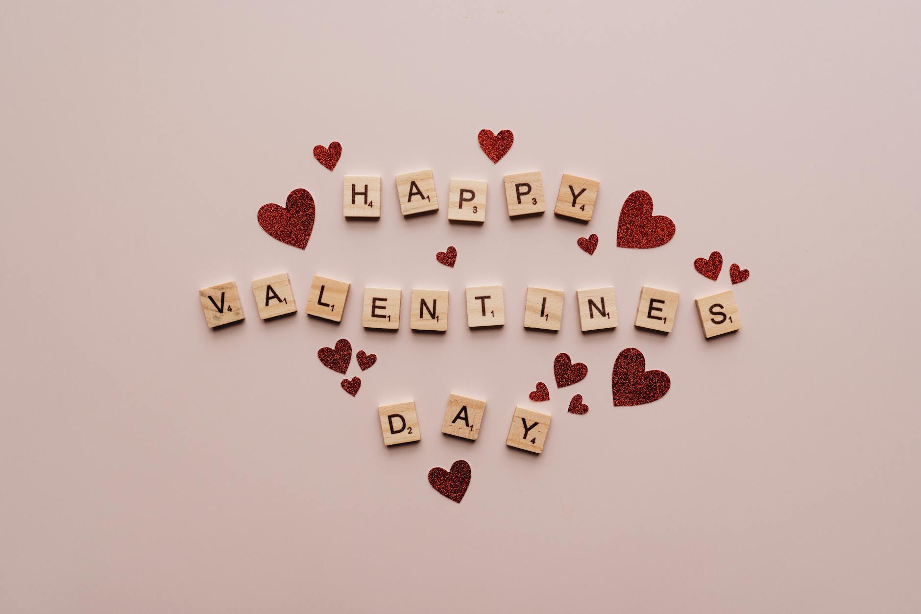 A festive Valentine's Day greeting with Scrabble tiles and red glitter hearts on a soft background. - valentine's day divorce parenting