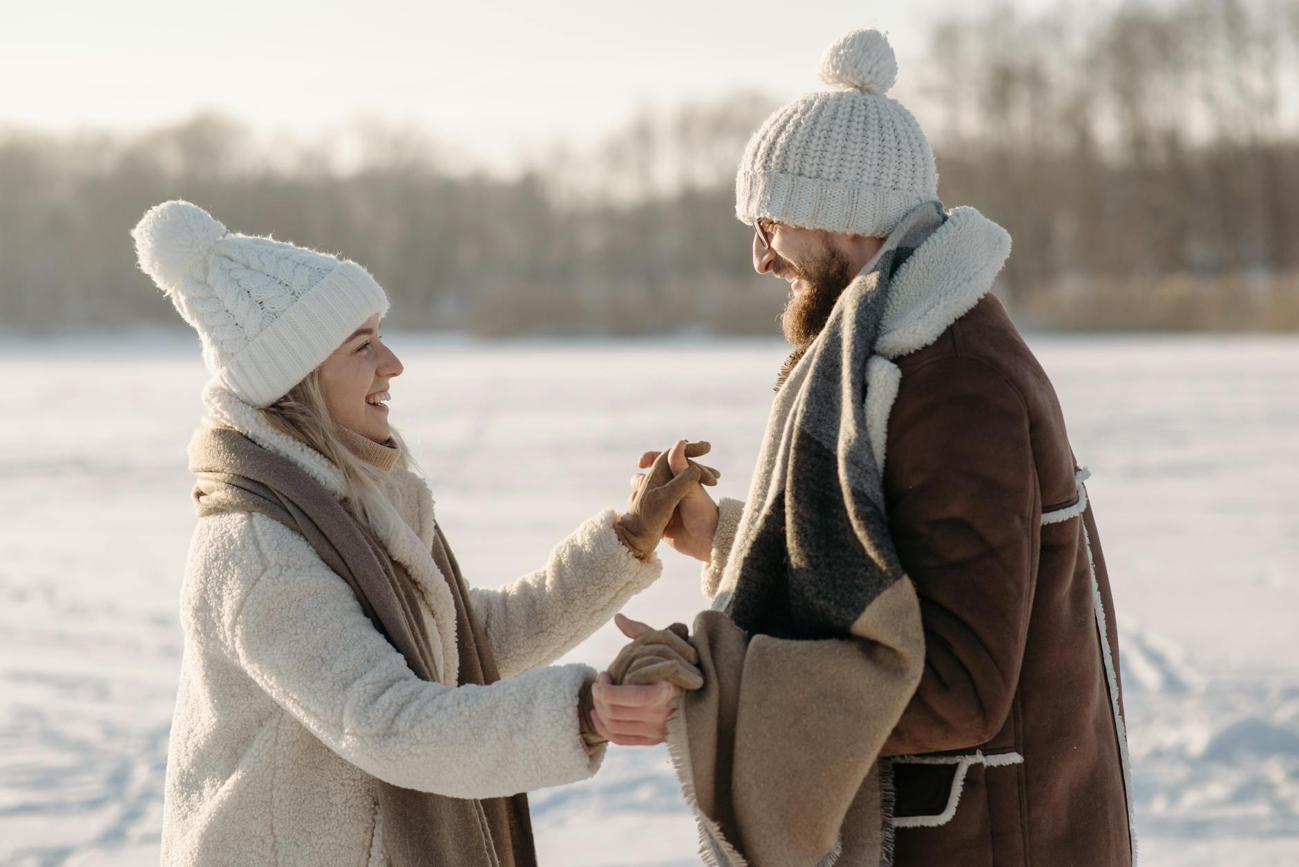 Joyful couple holding hands in snowy winter scene outdoors. - winter happiness couples