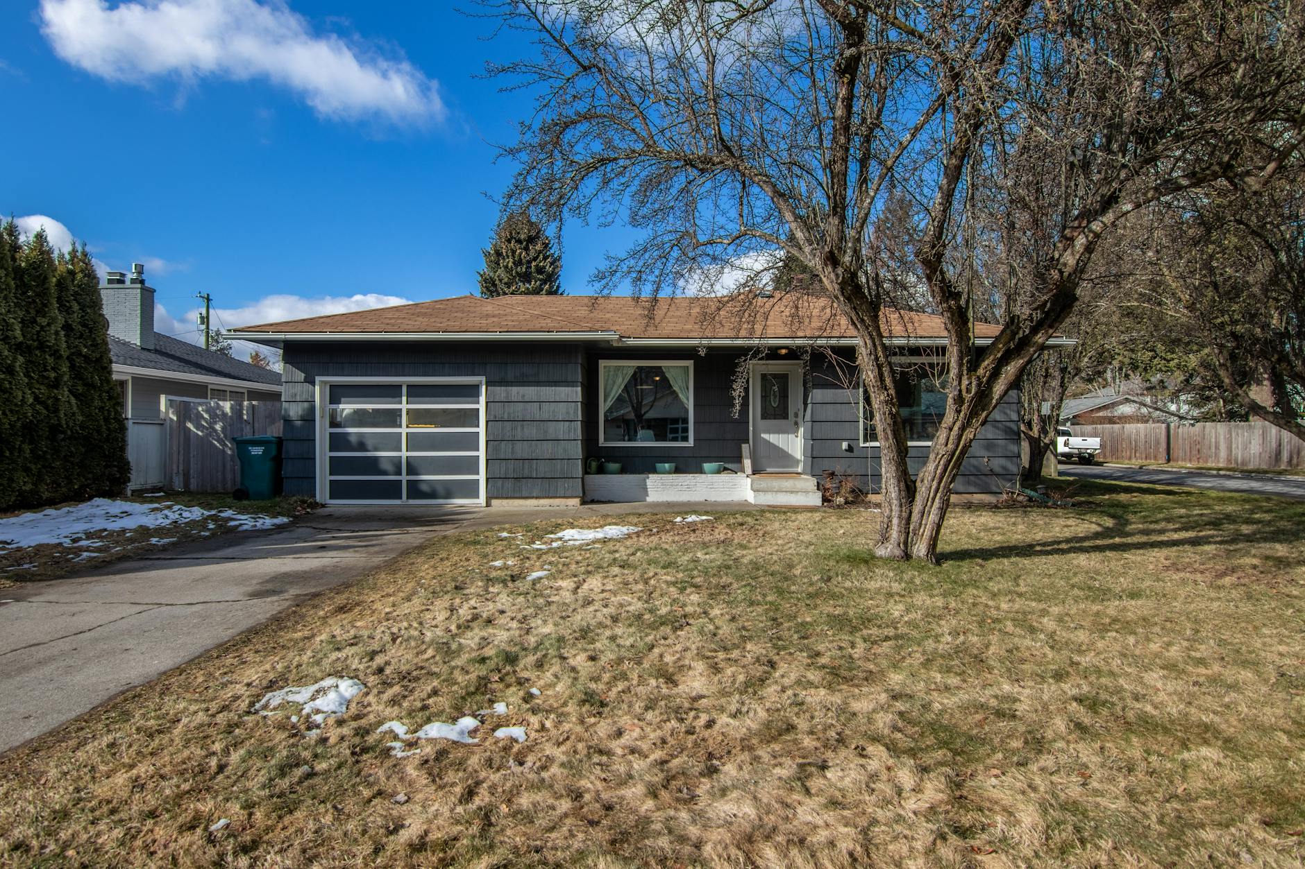 A quaint suburban house with a tree-lined front yard on a crisp, sunny day. - winter proximity attachment styles