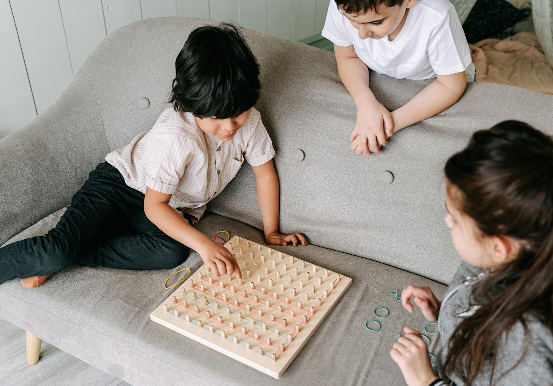 Three children playing an educational board game, promoting playful learning and interaction. - winter social skills for kids