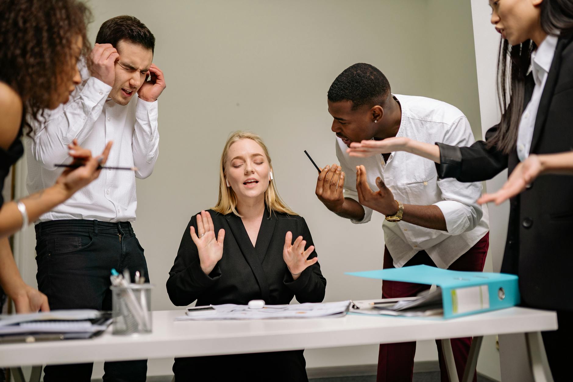 Diverse employees engaged in a heated discussion at a workplace meeting, showcasing stress and tension. - workplace conflict resolution the office