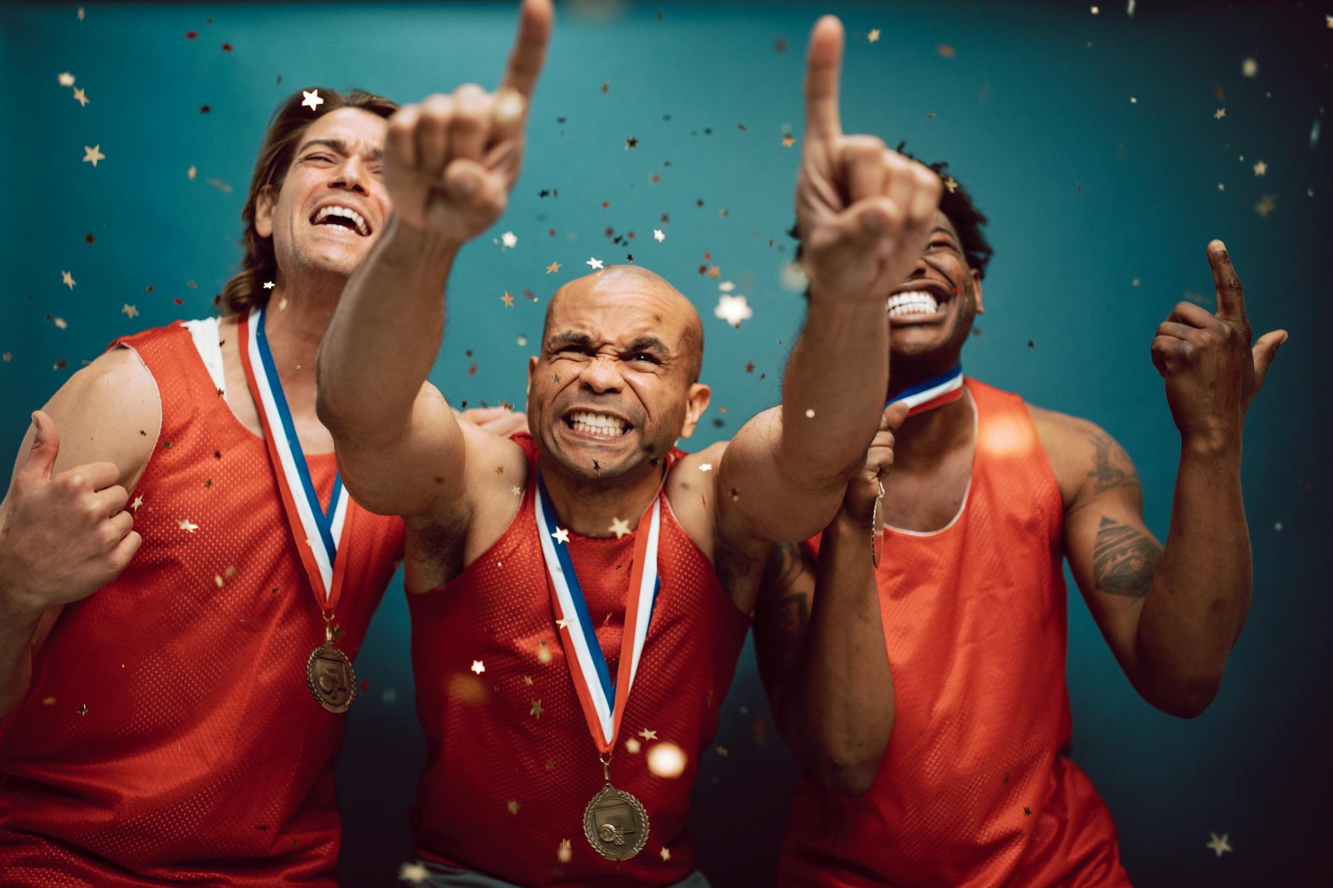 Three athletes celebrating victory with medals and confetti against a blue background. - achievable therapy goals