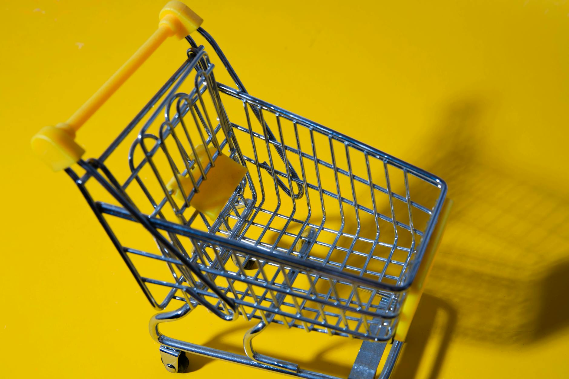 Close-up of a small toy shopping cart on a vibrant yellow backdrop. - active listening examples