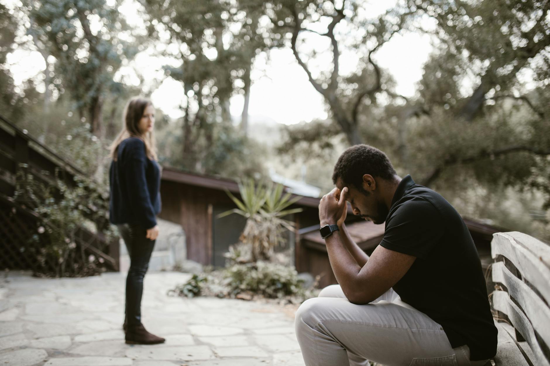A couple in a tense moment, outdoors on a bench, focusing on emotional distress. - apologize to a man