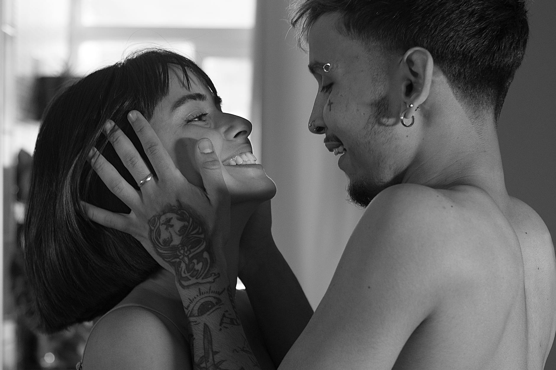 A joyful couple sharing a tender moment indoors, captured in black and white. - avoidant attachment style