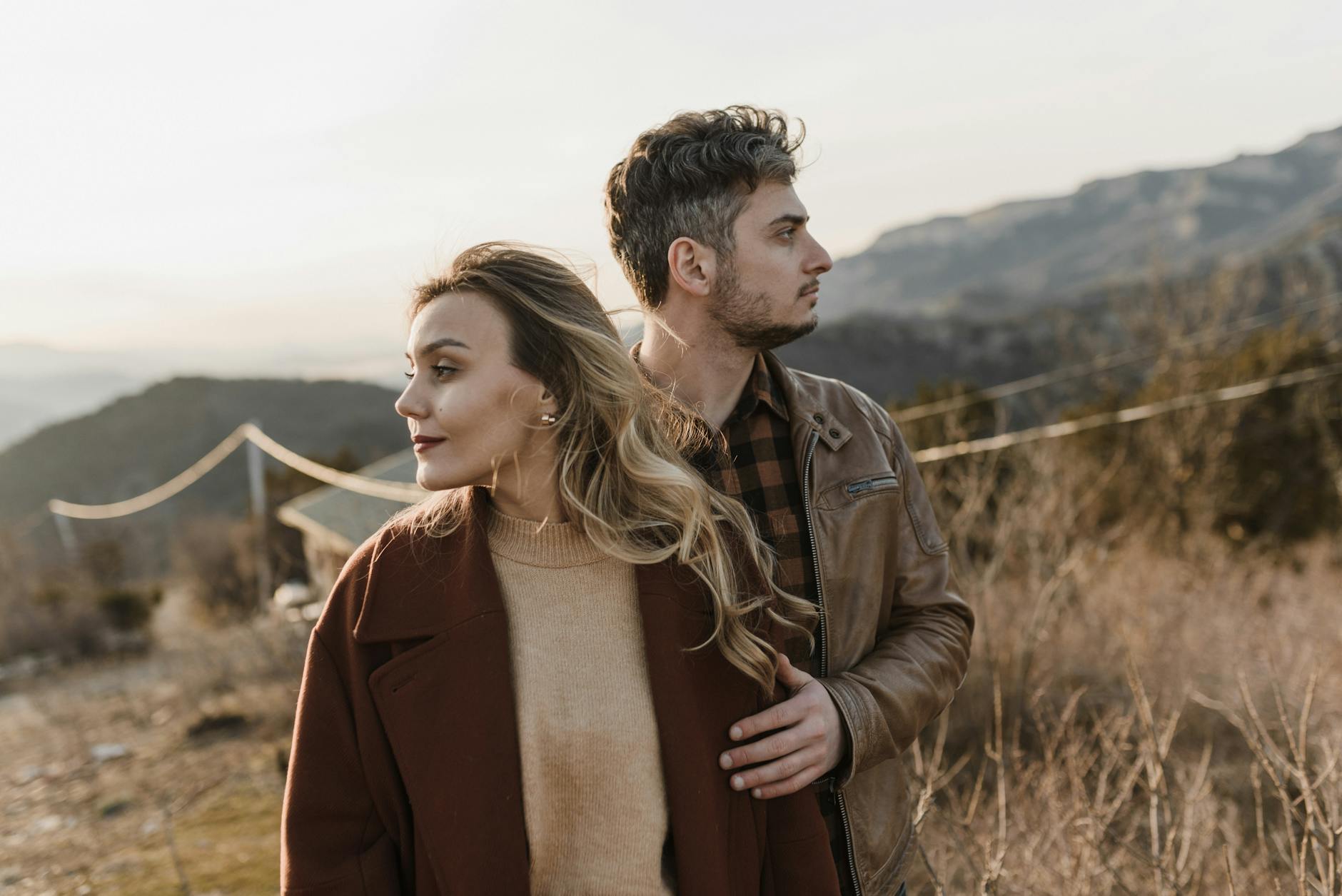 A couple embraces amidst a scenic mountain landscape, capturing a moment of love and connection. - avoidant attachment style