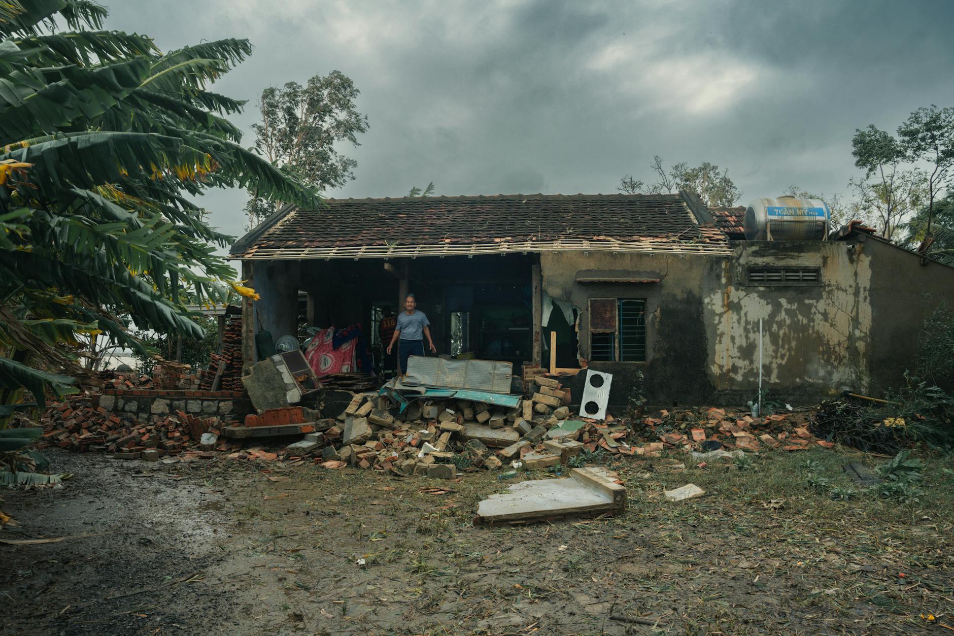 A rural house in Phú Yên, Vietnam, heavily damaged by a storm, showcasing nature's impact. - building resilience