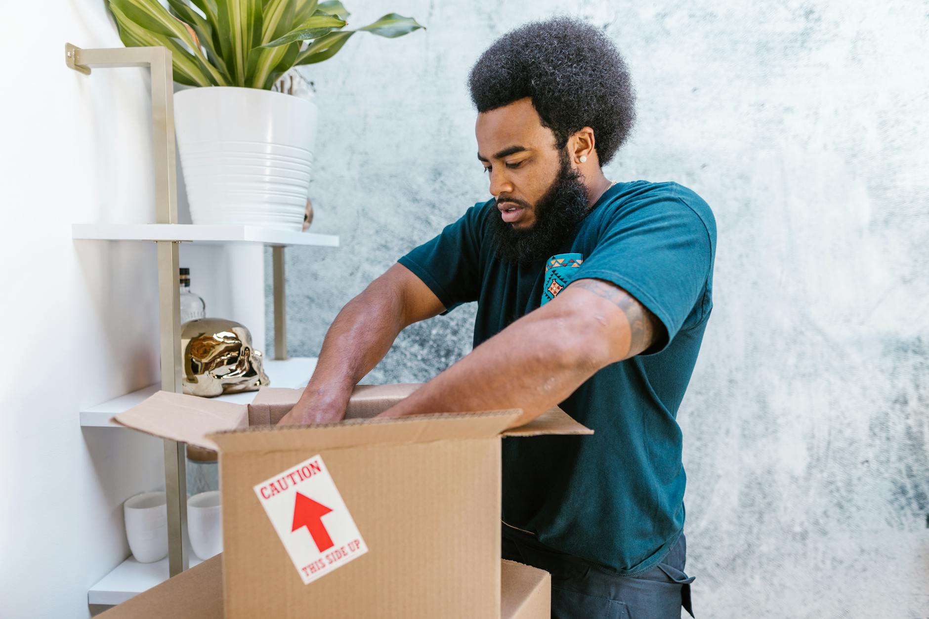 A professional mover packs a fragile item into a box in a stylish room. - couple communication tips