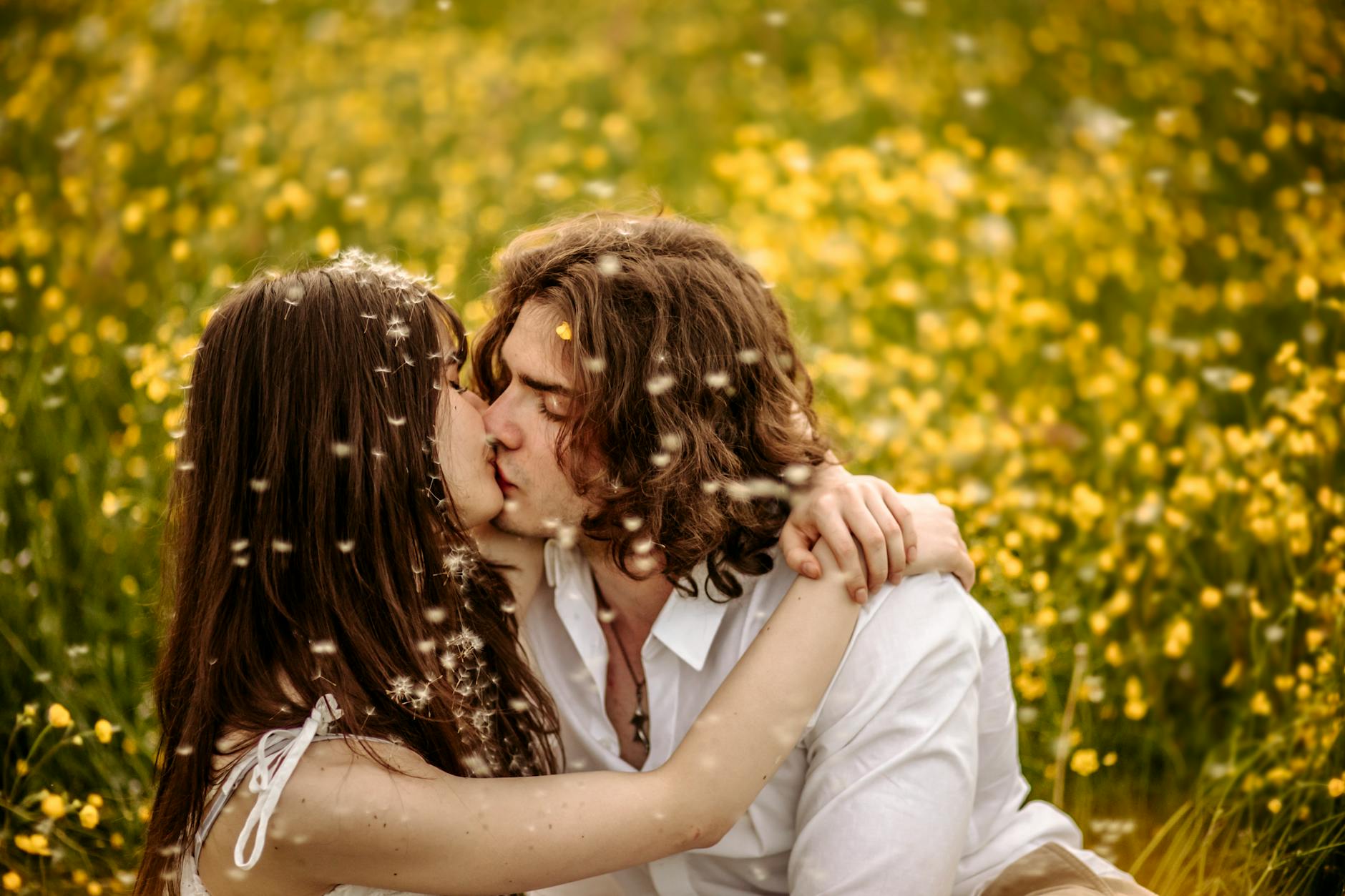 A loving couple shares a romantic kiss in a vibrant meadow filled with flowers. - couple resentment spring