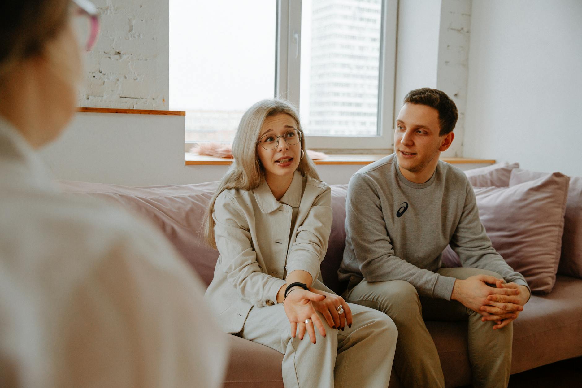 A couple and therapist engaged in a discussion during a therapy session indoors. - couples counseling communication